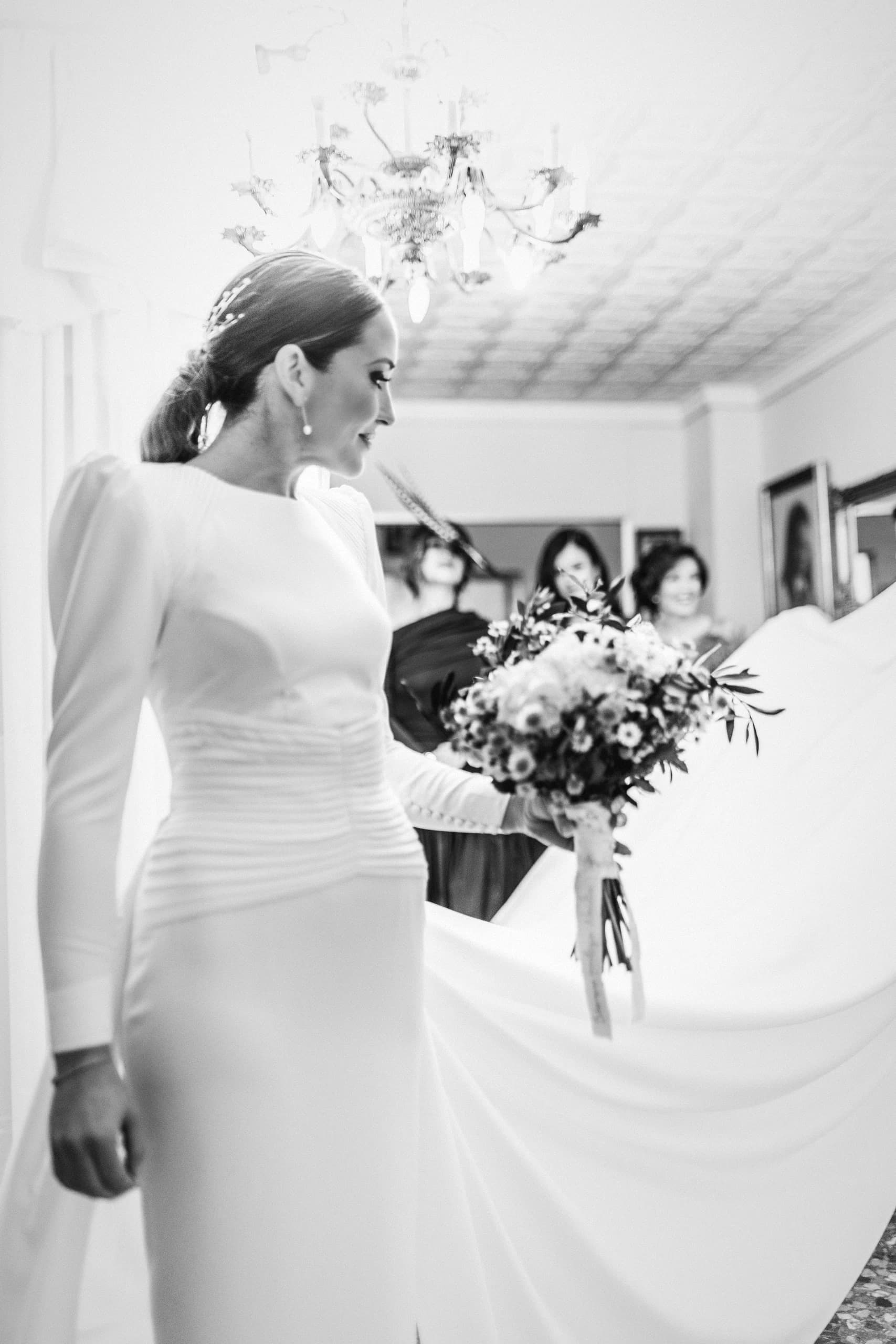 La novia asomada a la ventana con el ramo en las manos
