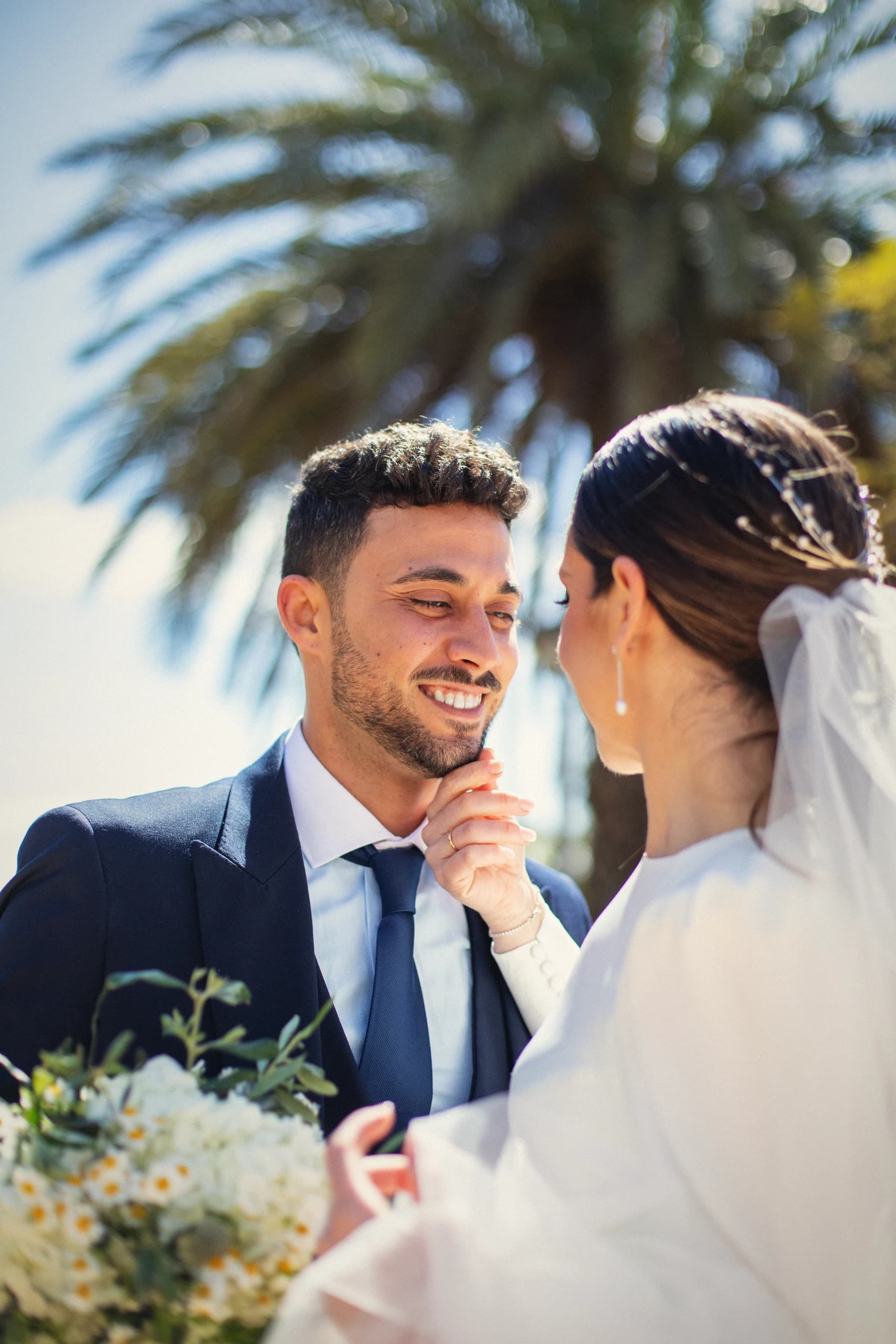 Los novios frente a frente bajo una palmera