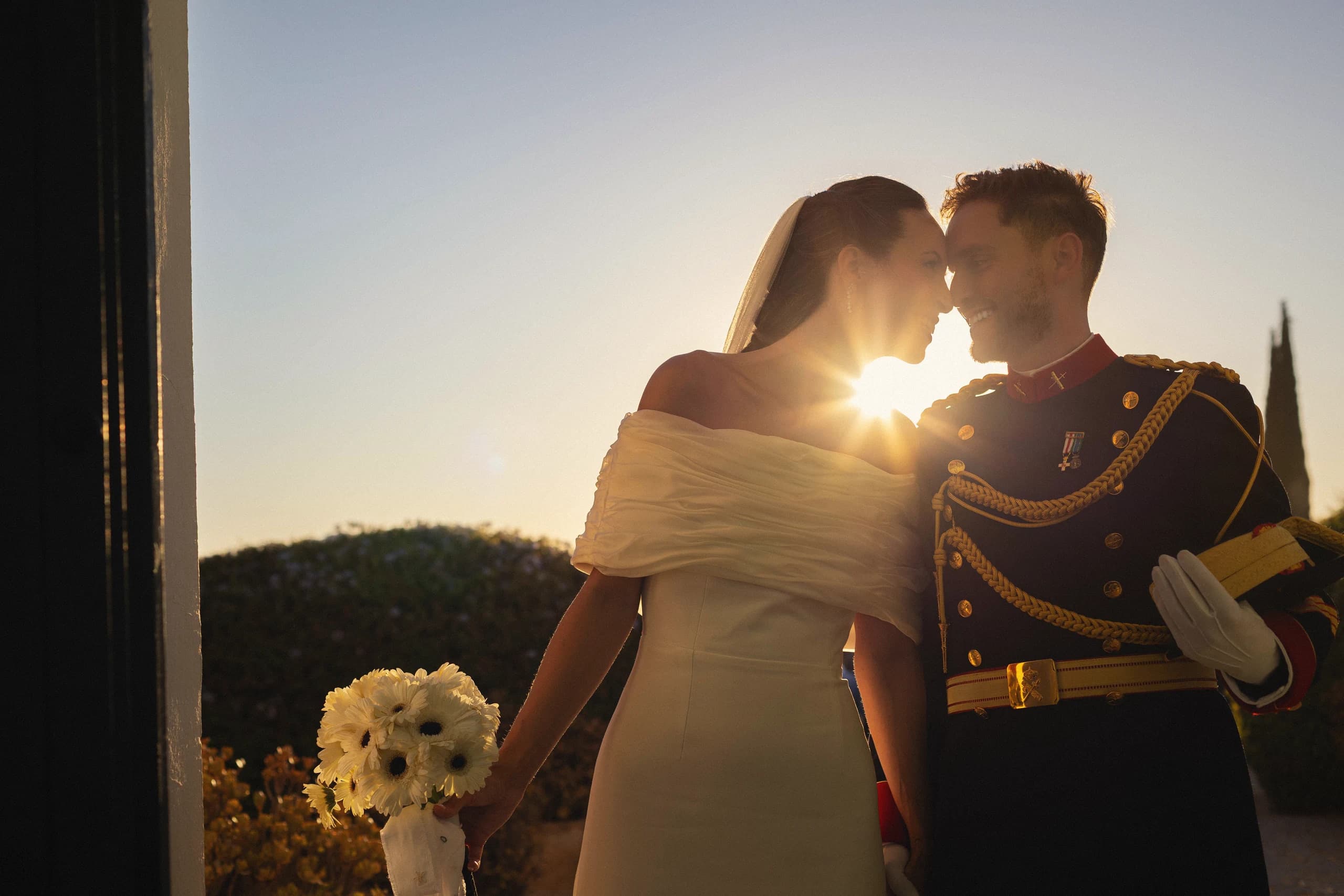 Los novios a contraluz, con el sol poniéndose entre los dos