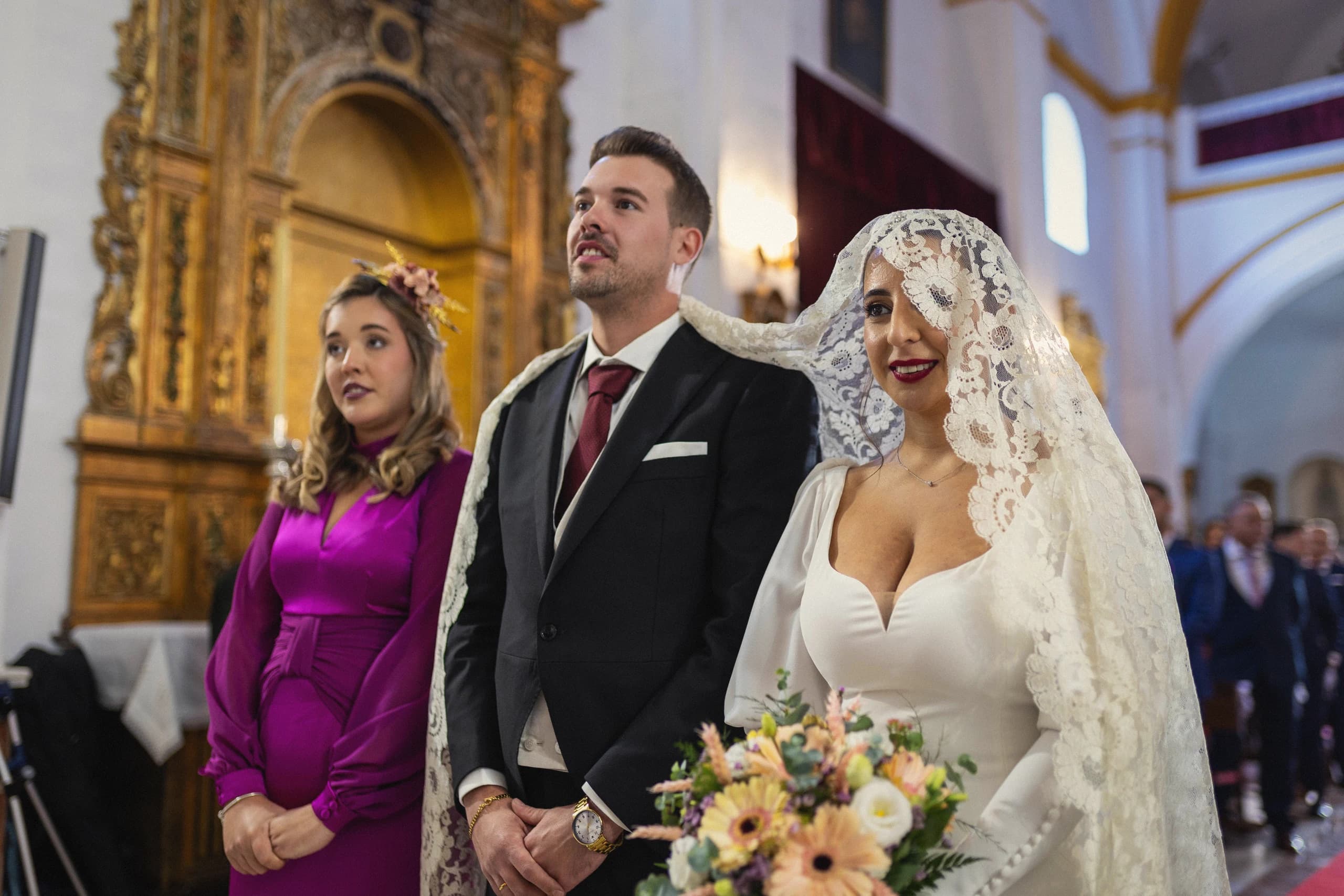 Los novios en el altar con la mantilla de la novia