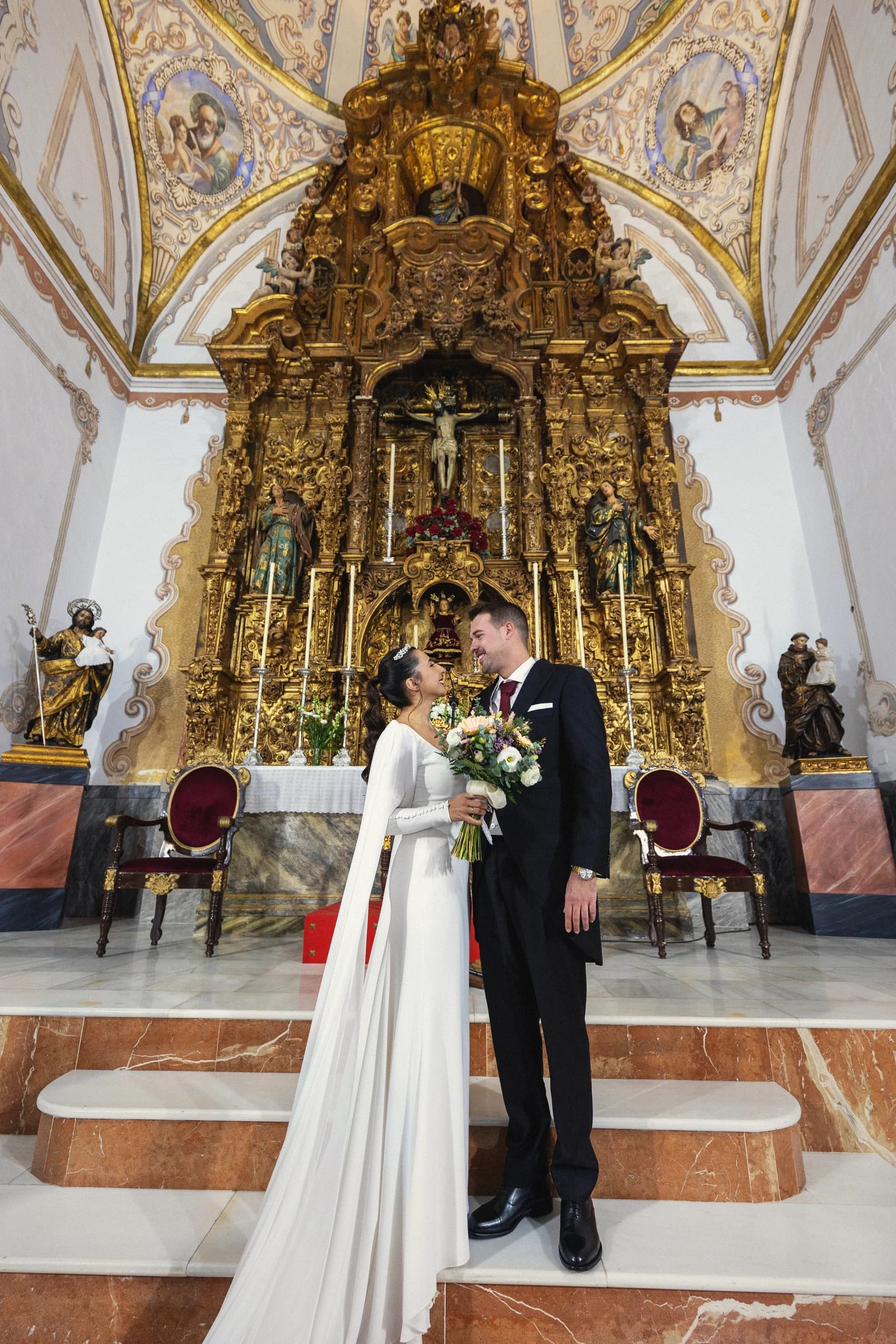 Los novios ante el retablo dorado de la iglesia