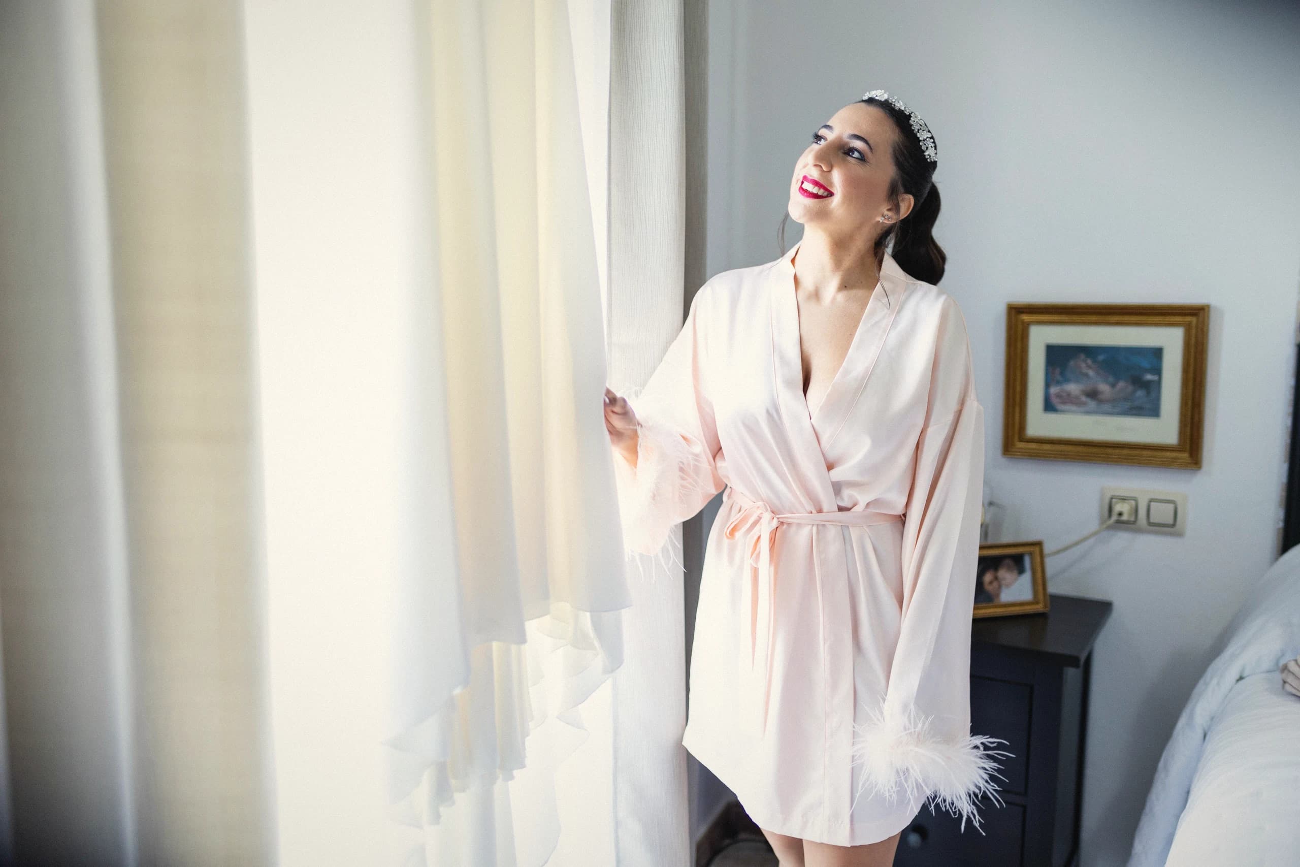 La novia en bata junto a la ventana, antes de vestirse