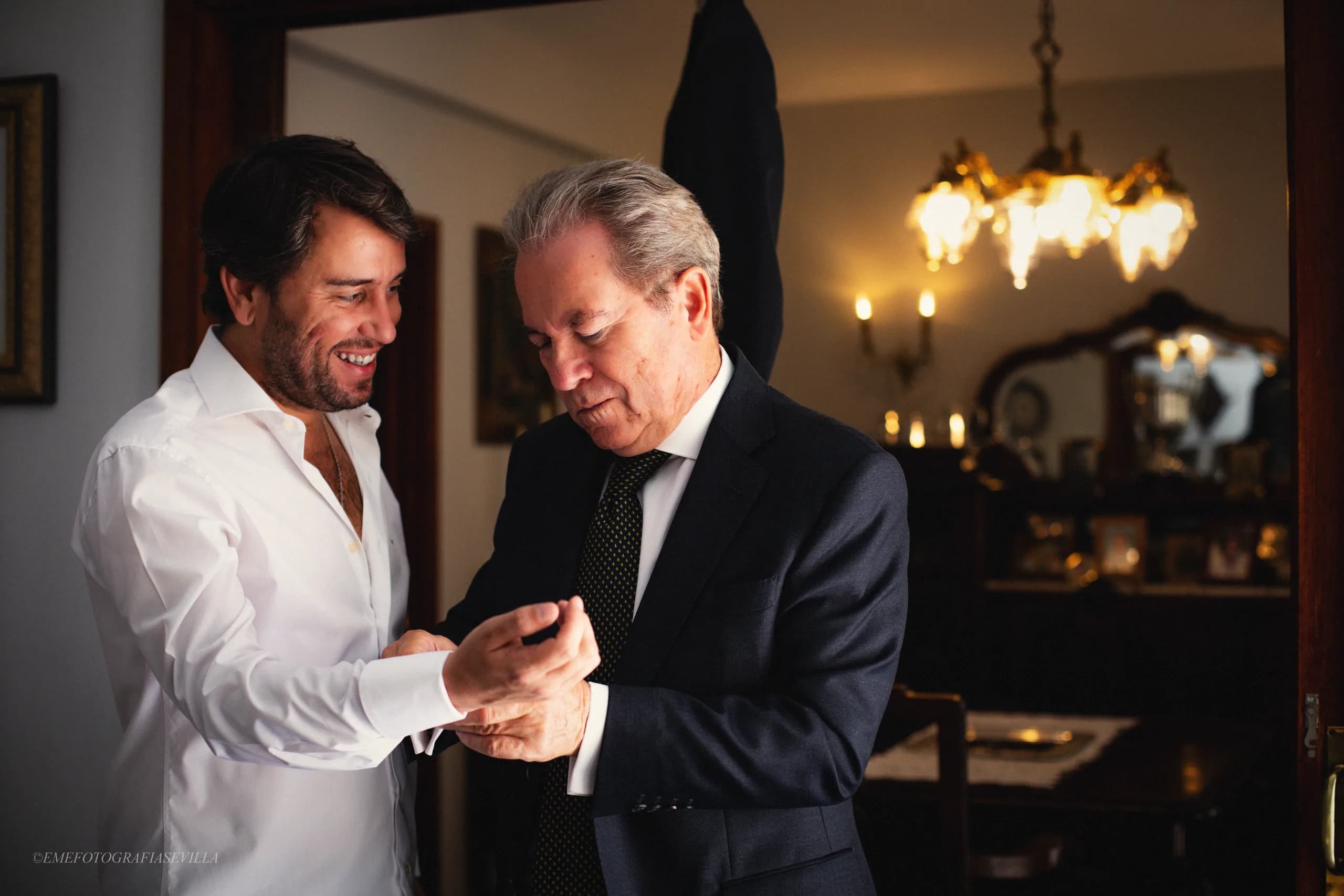 Su padre abrochándole el gemelo al novio en el salón de casa