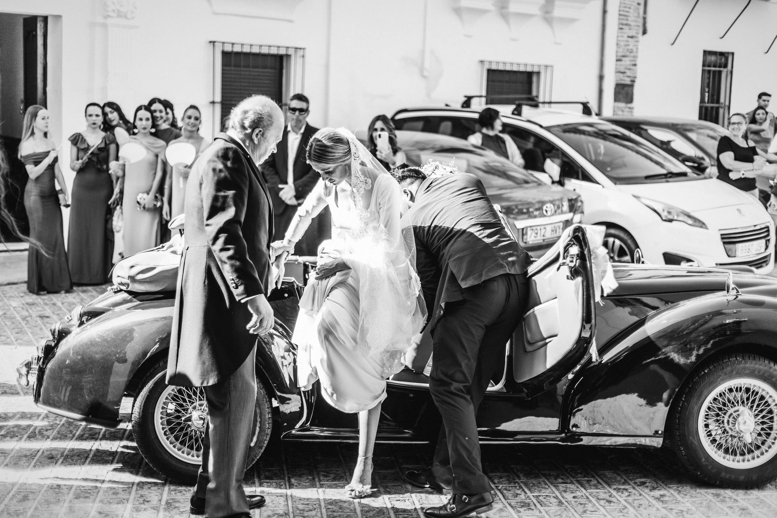 Bajando del coche clásico a la puerta de la iglesia, en blanco y negro