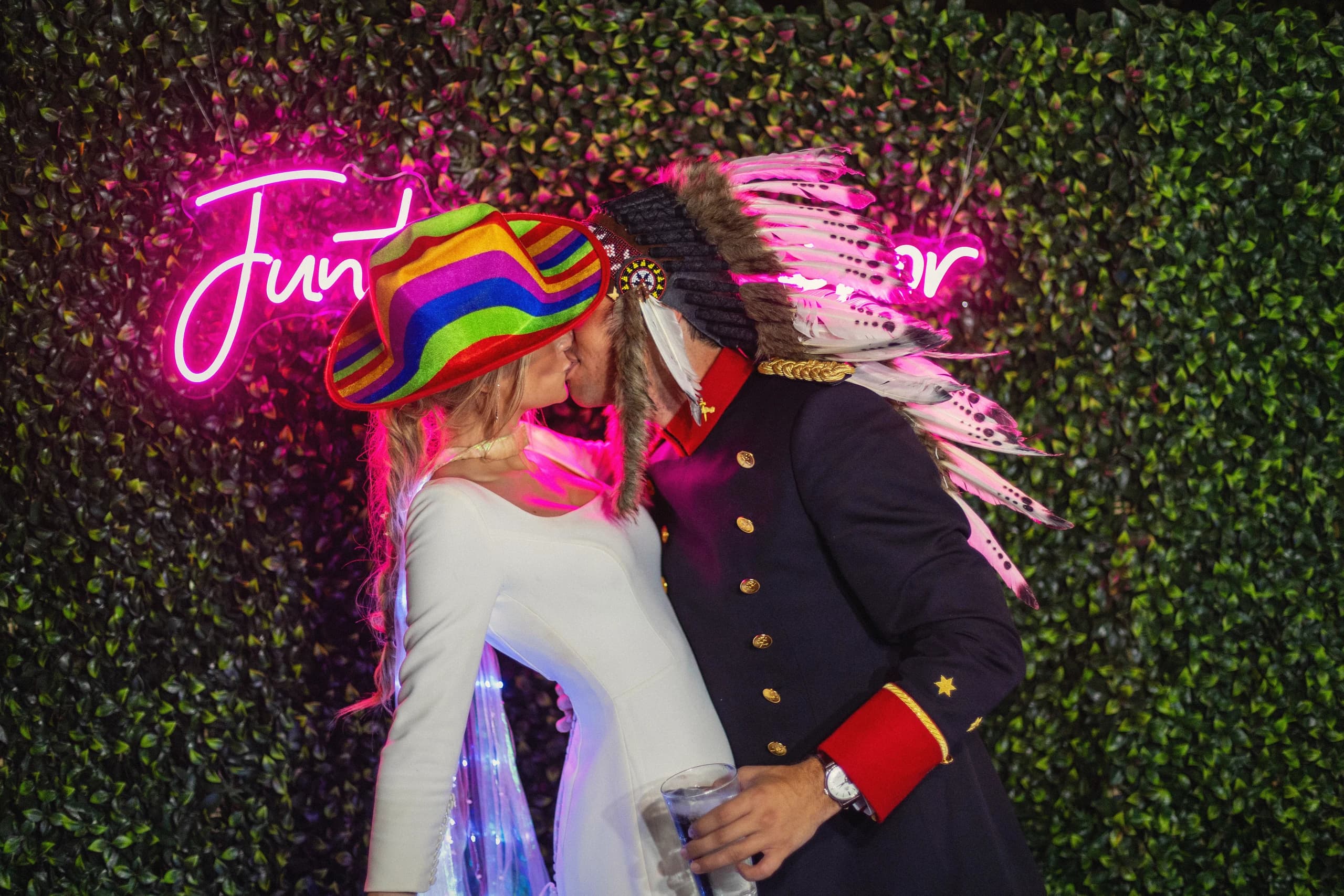 Beso bajo el neón «Juntos es mejor» en la fiesta