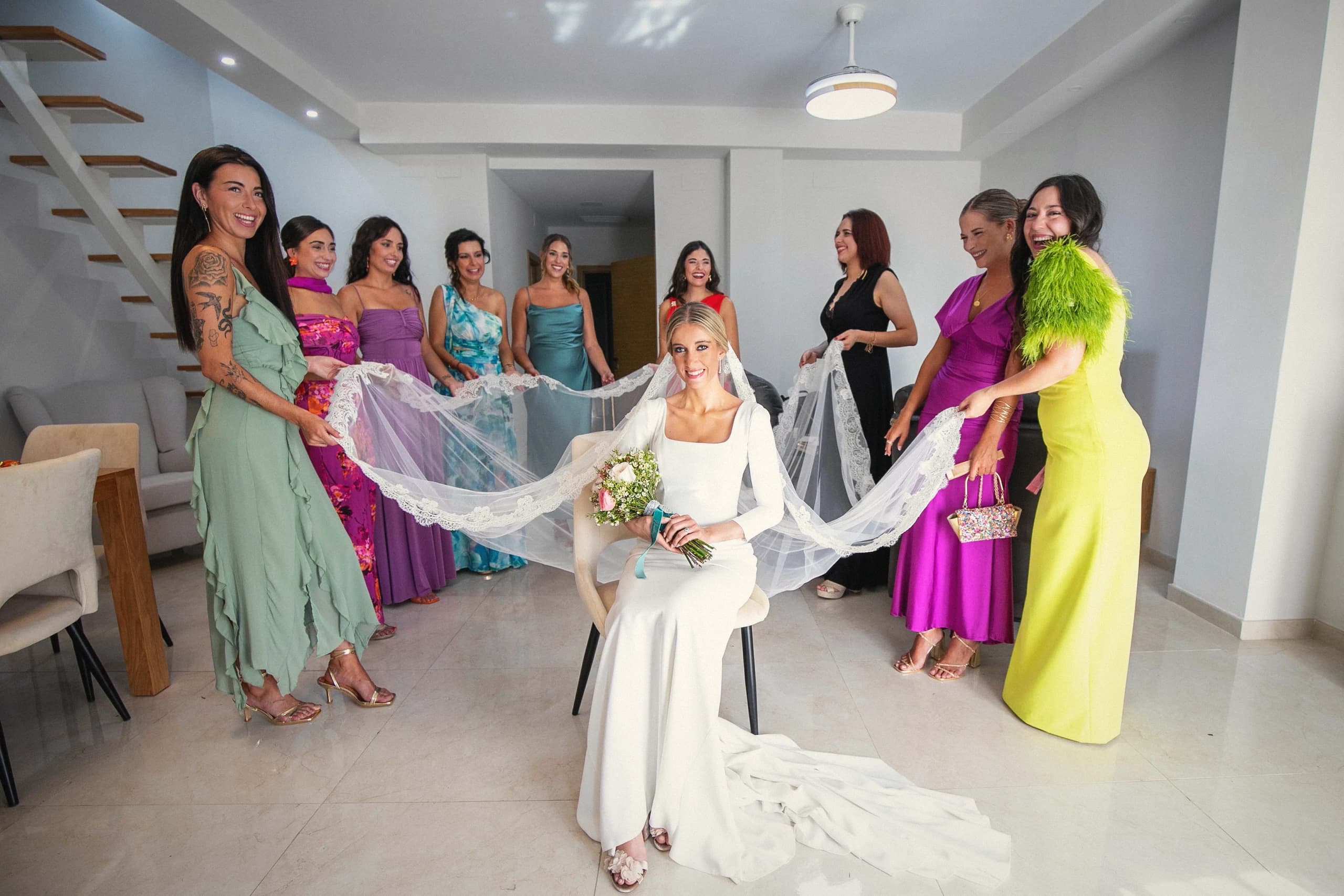 La novia con sus damas sujetando el velo antes de salir