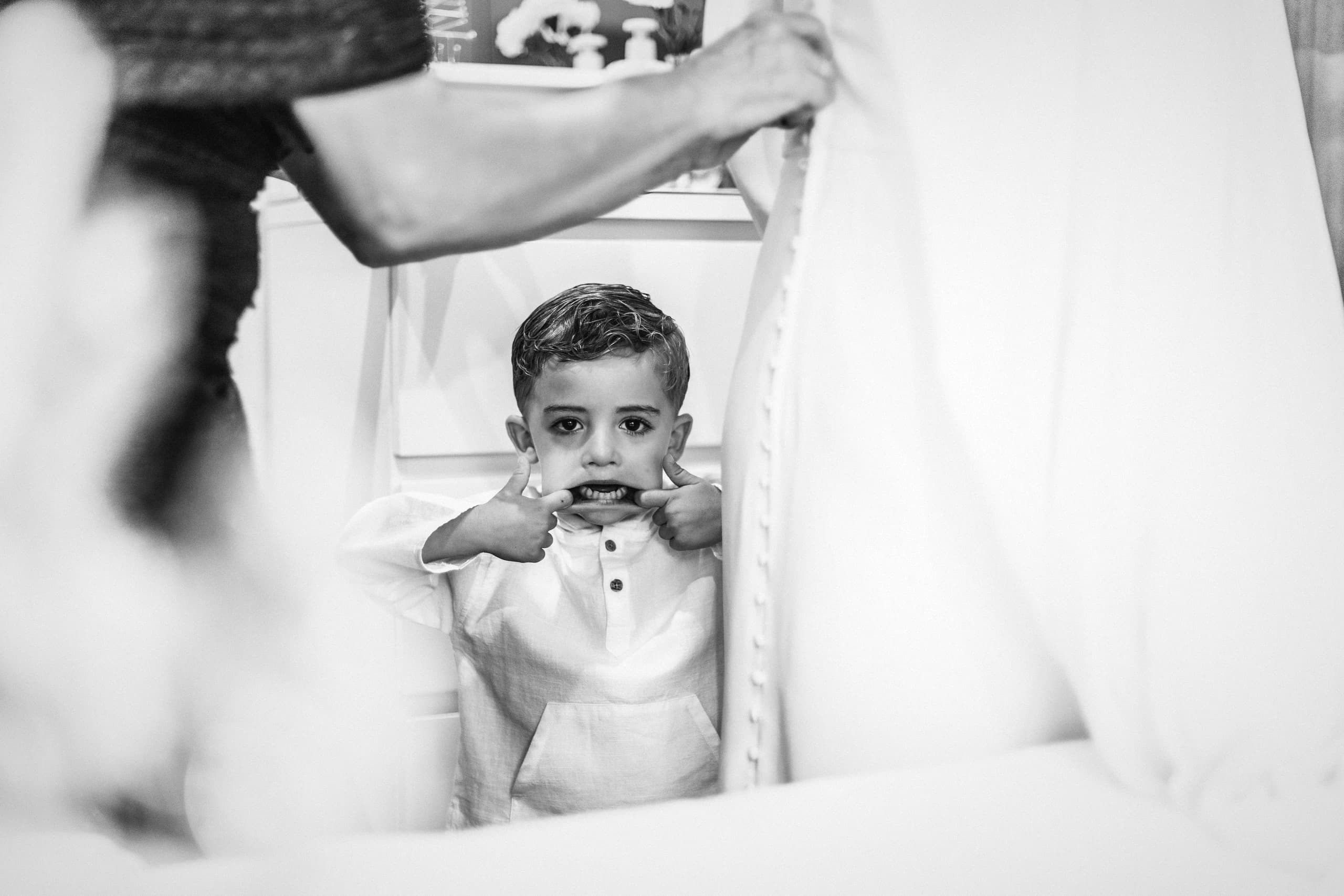 El niño asomándose entre el vestido de la novia