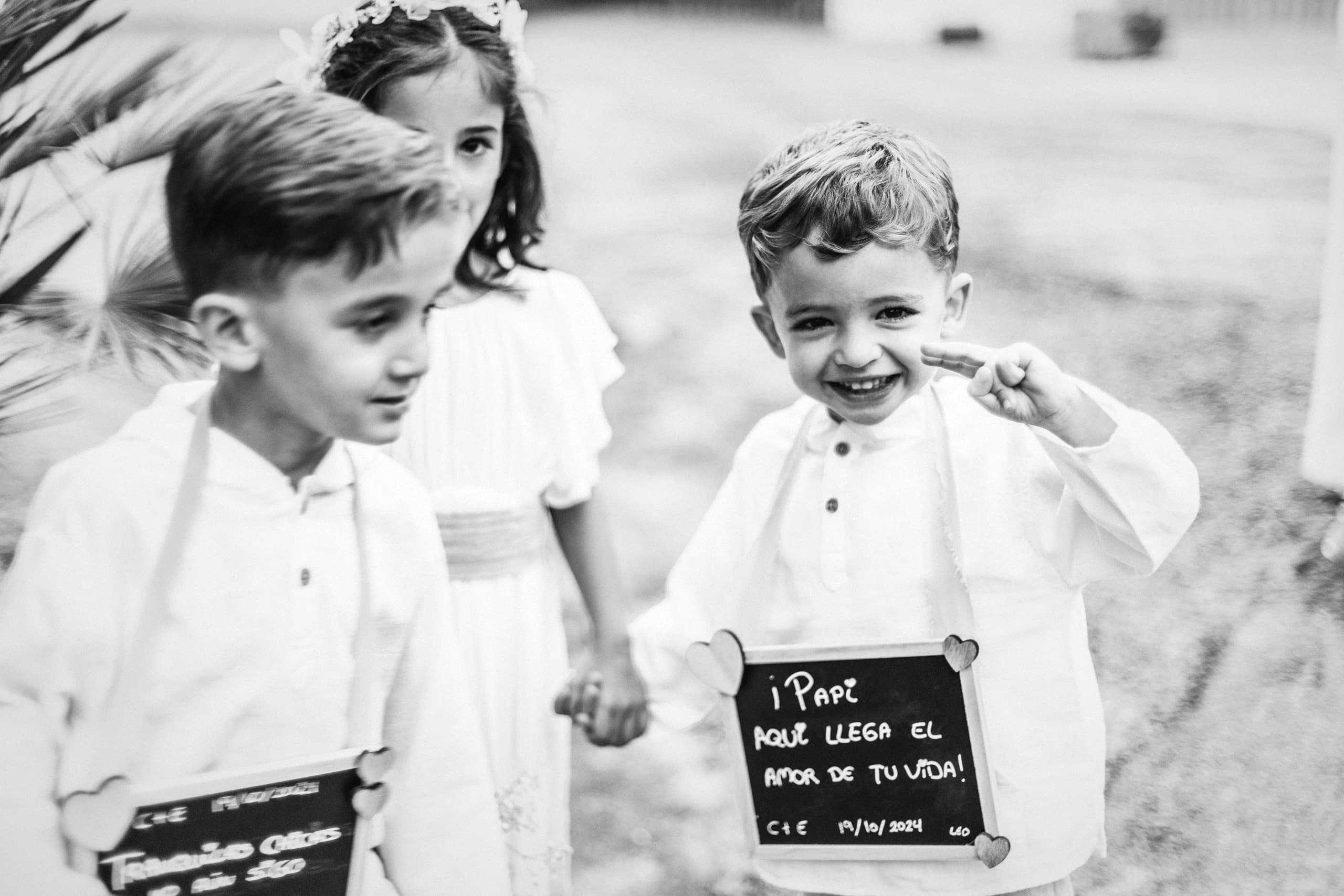 Los pajes con la pizarra «Aquí llega la novia», en blanco y negro