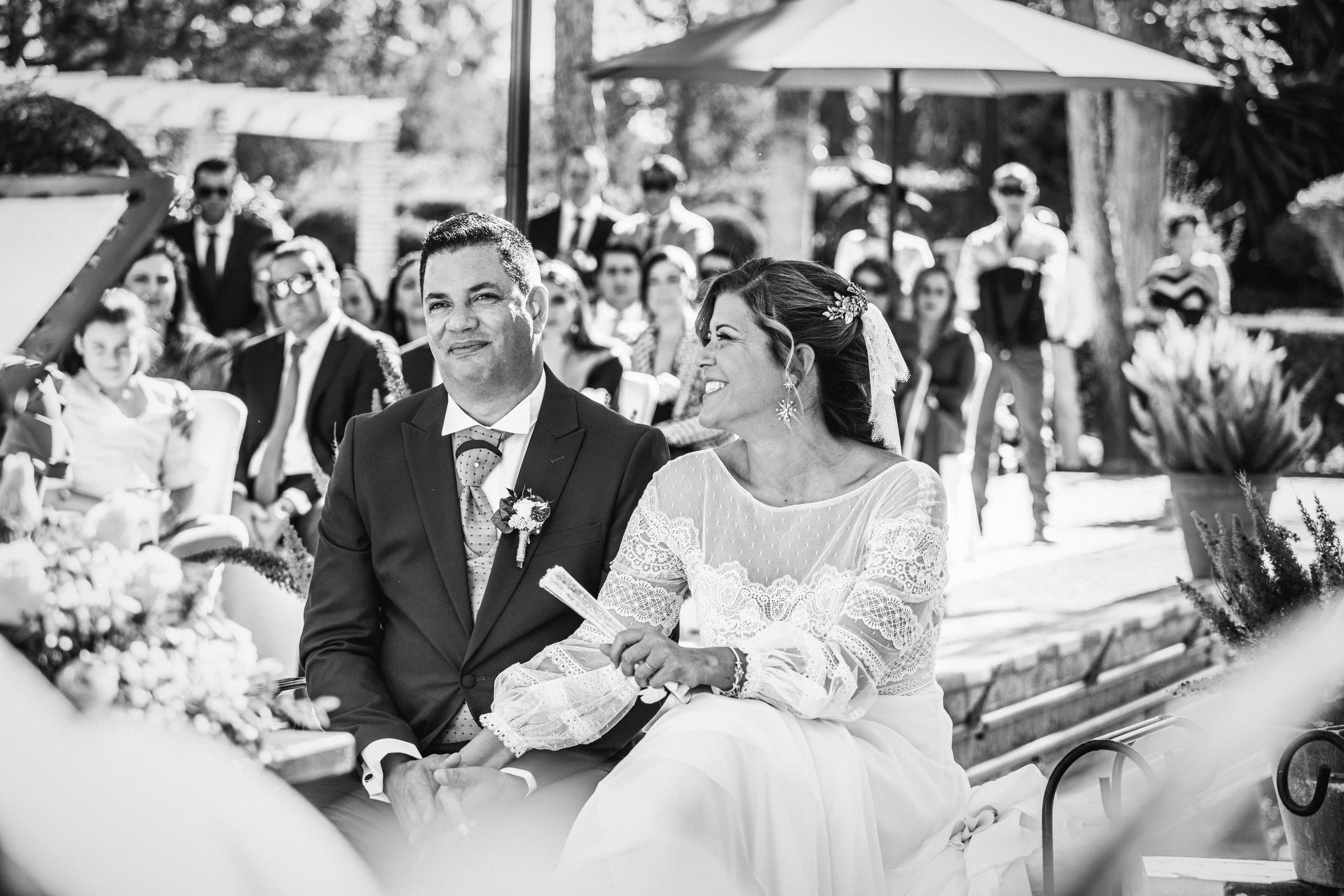 Los novios riendo durante la ceremonia al sol