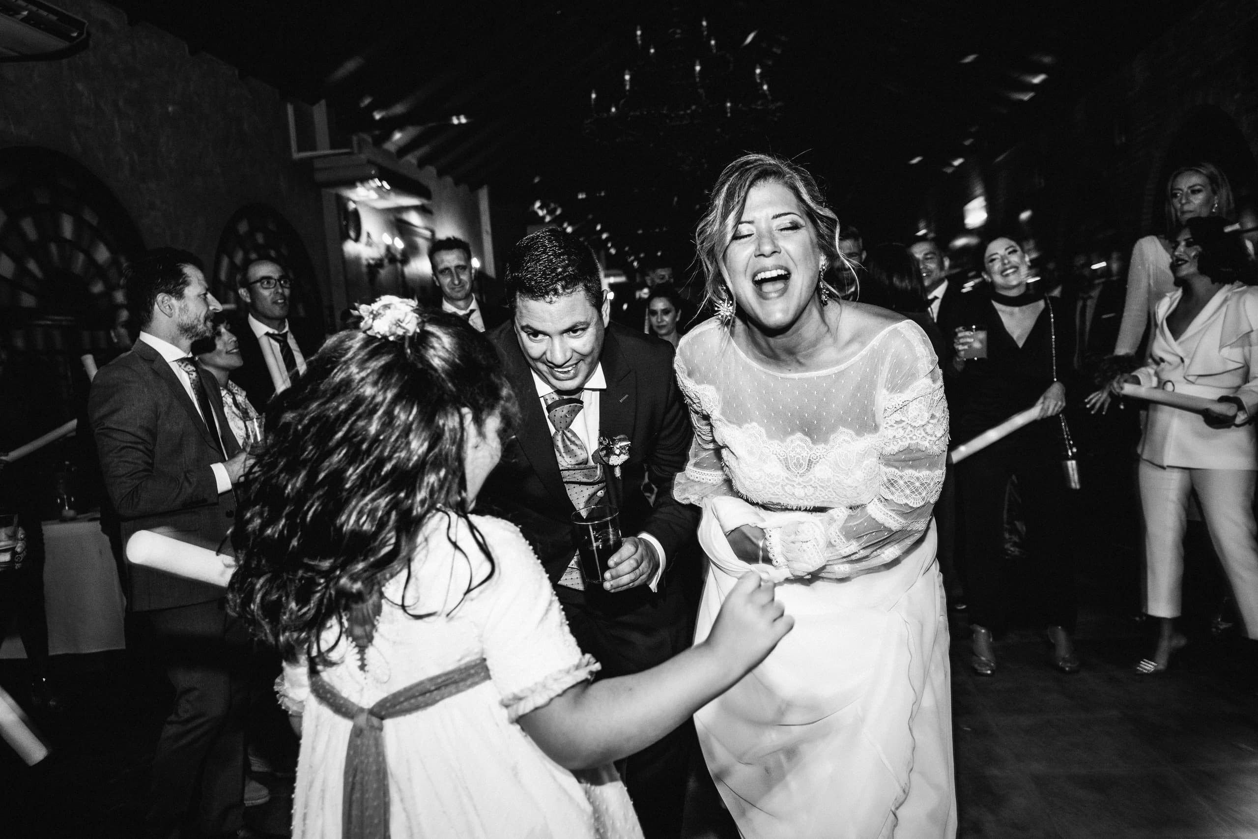 La novia bailando con las invitadas, en blanco y negro