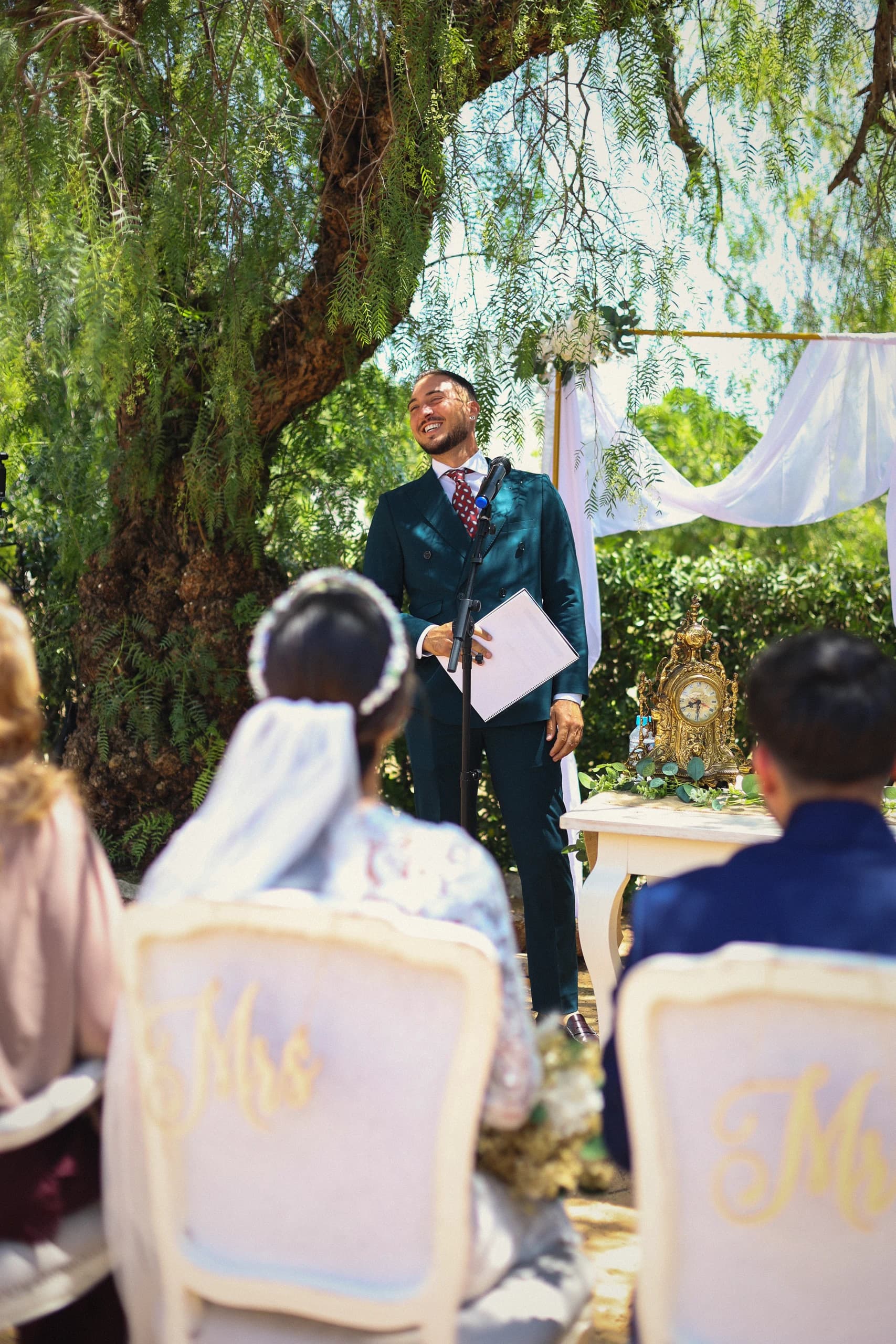 La novia sentada durante la ceremonia, bajo el sauce