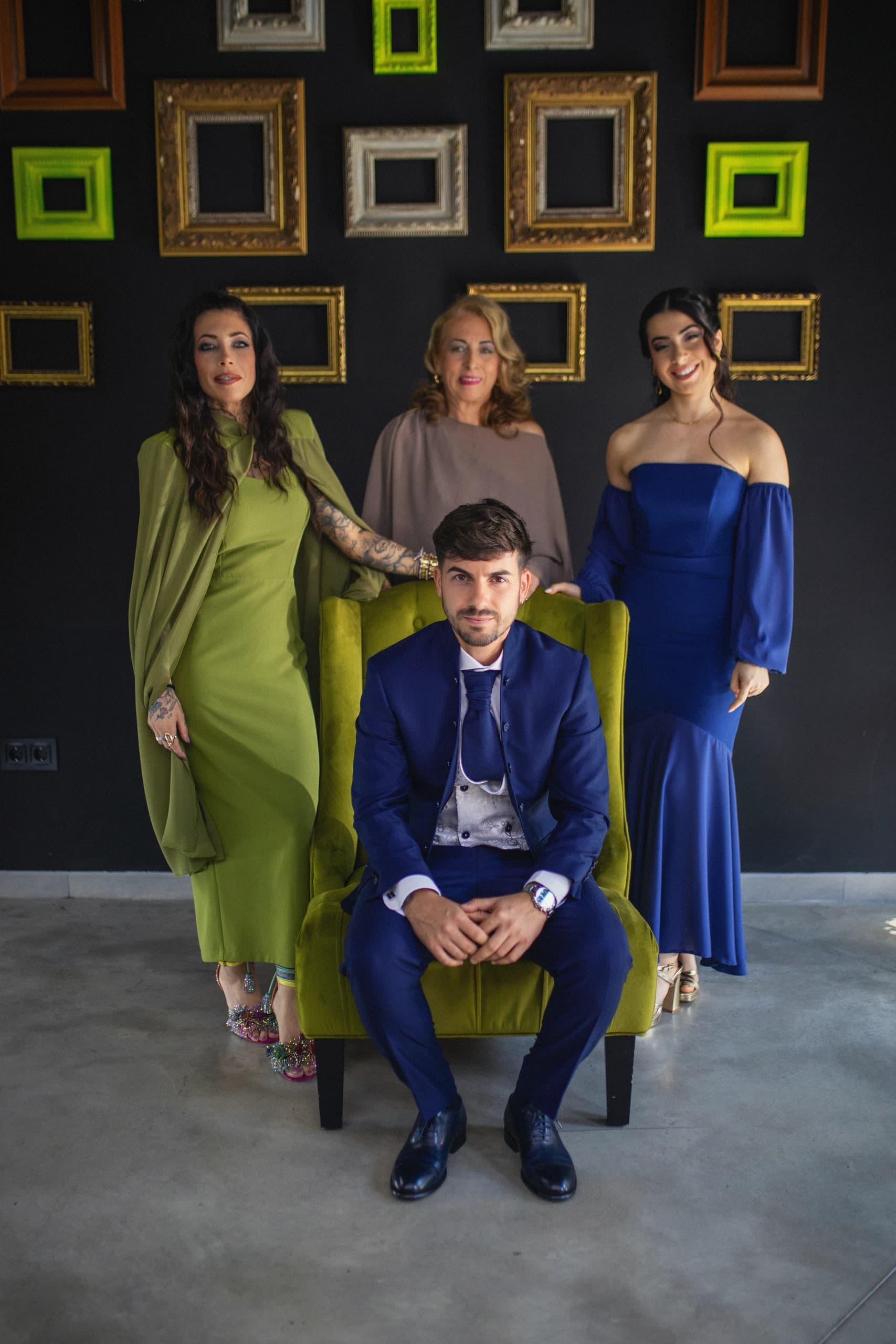 El novio sentado con las invitadas de verde y azul, en la sala de los cuadros