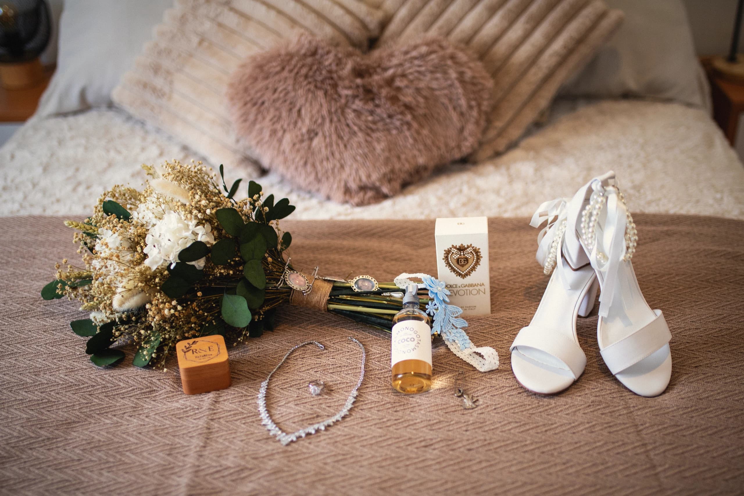 El ramo, los zapatos y las joyas de la novia sobre la cama