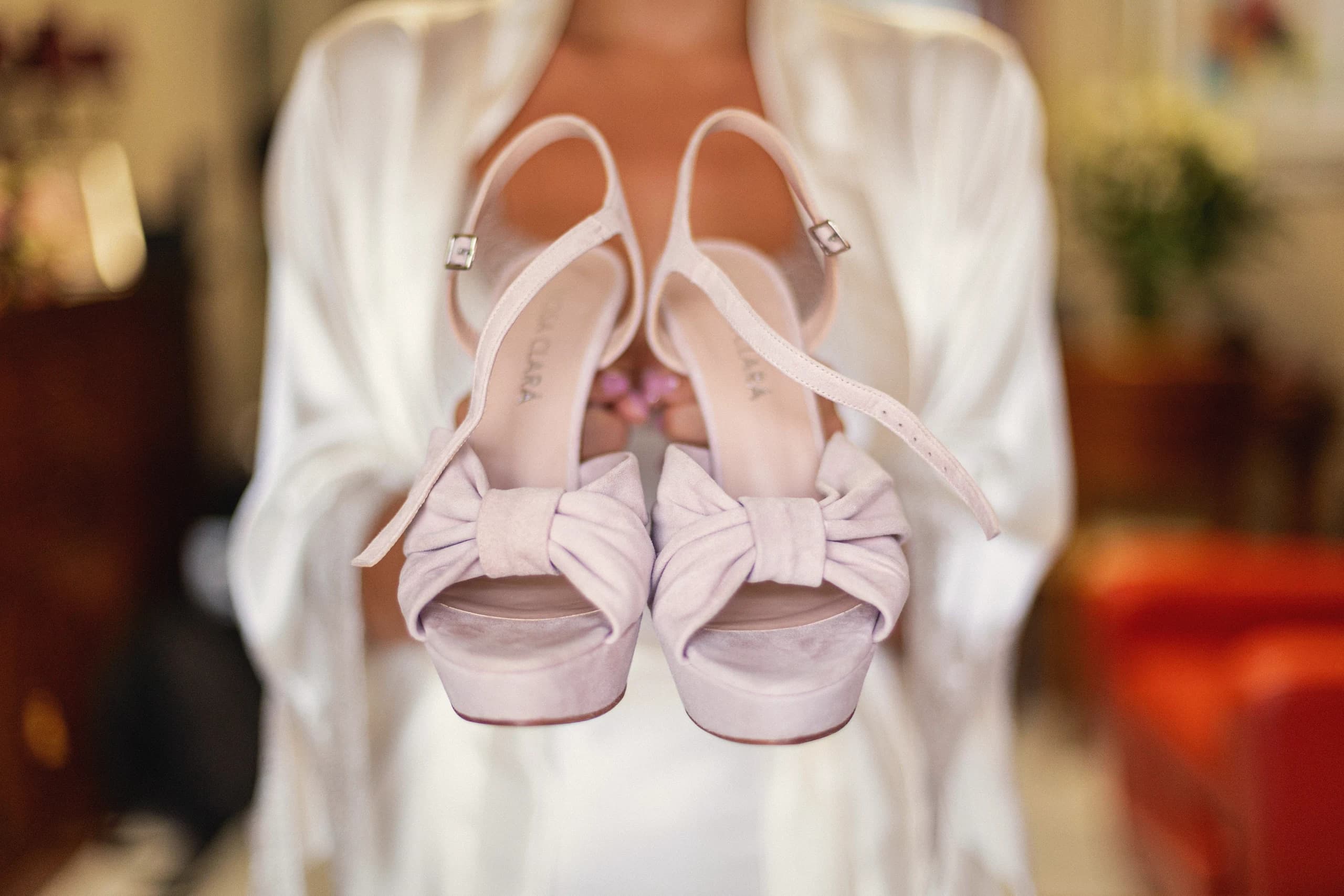 Los zapatos de la novia en sus manos