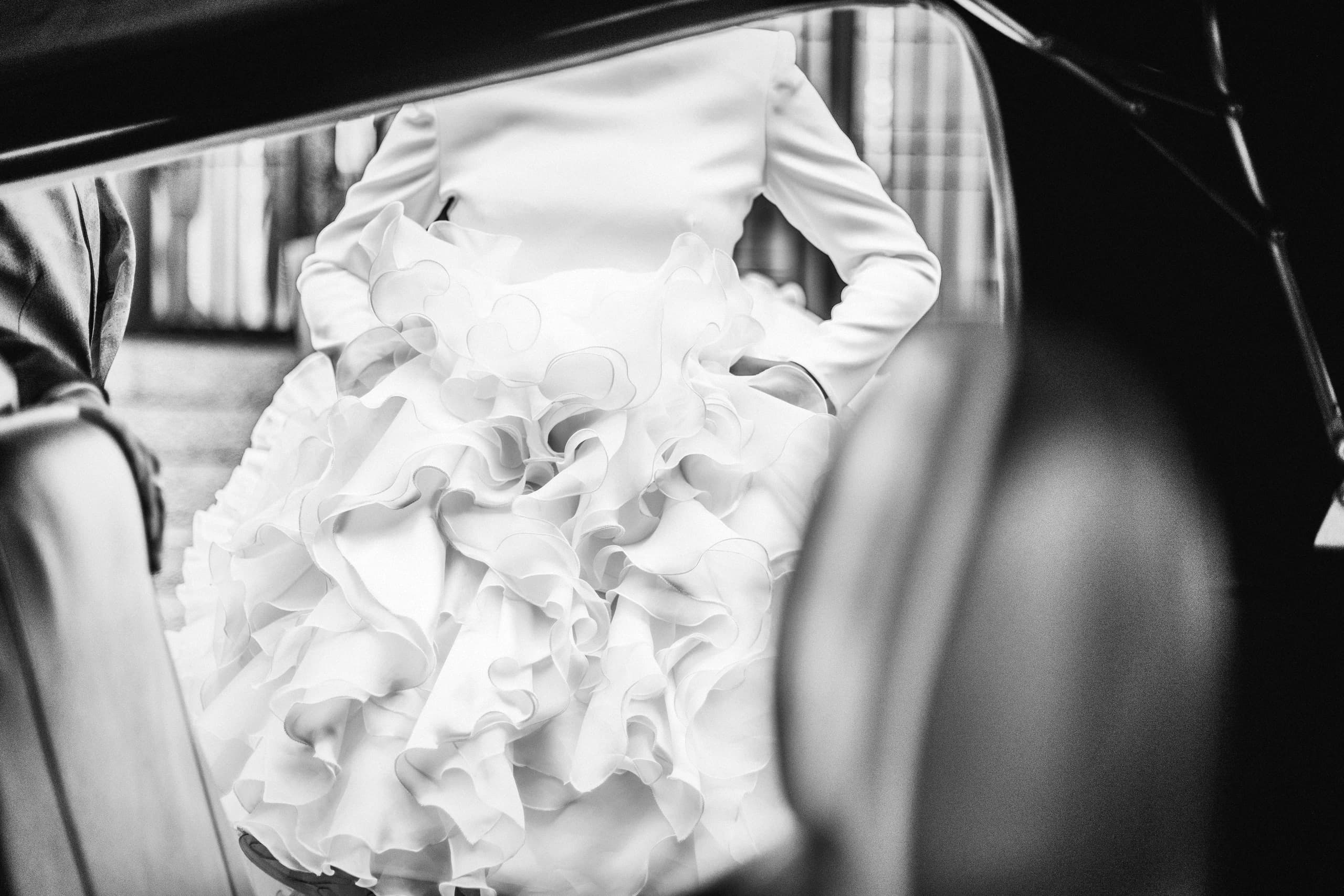 La cola del vestido saliendo del coche, en blanco y negro