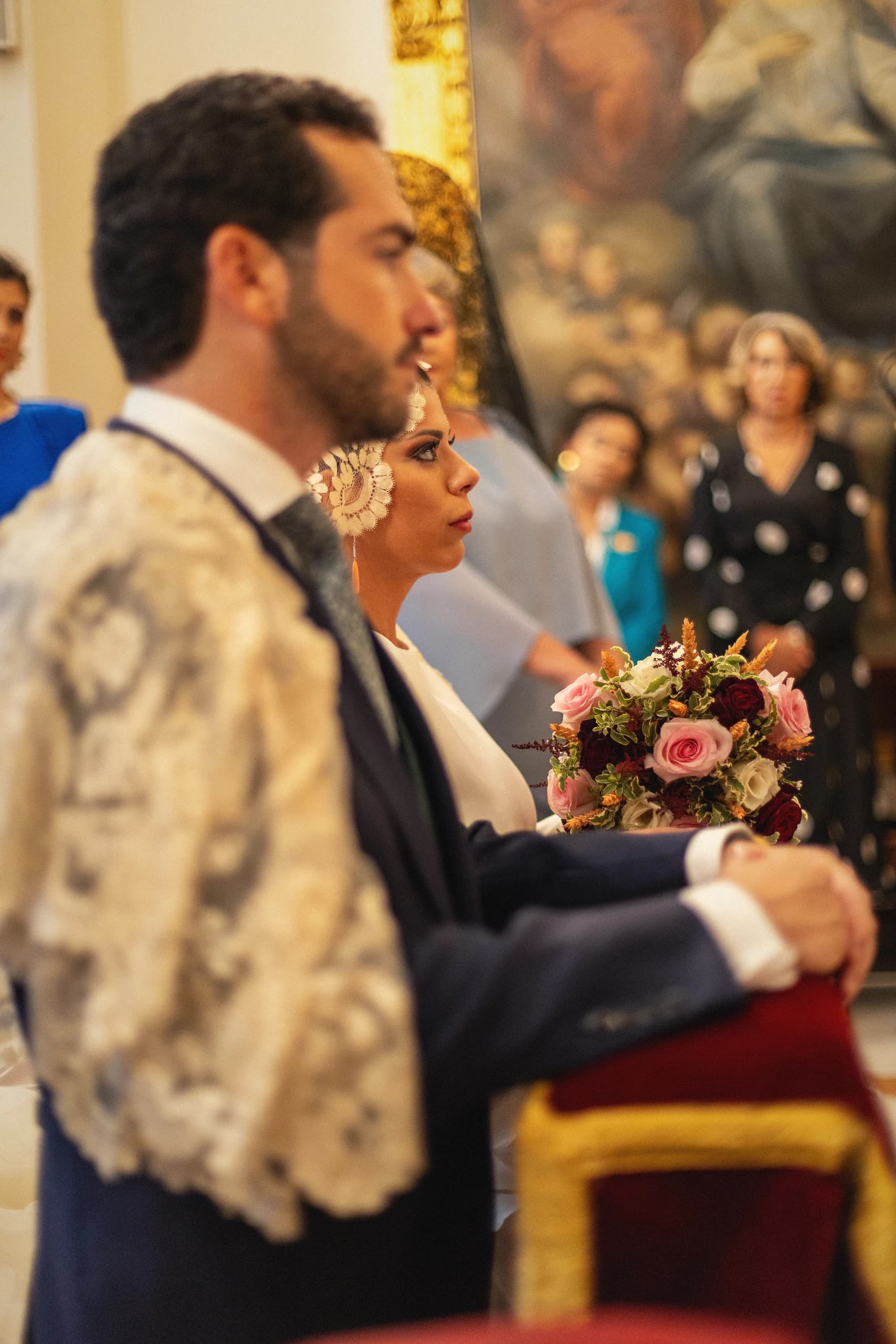 Los novios ante el altar, con la chaqueta bordada del novio