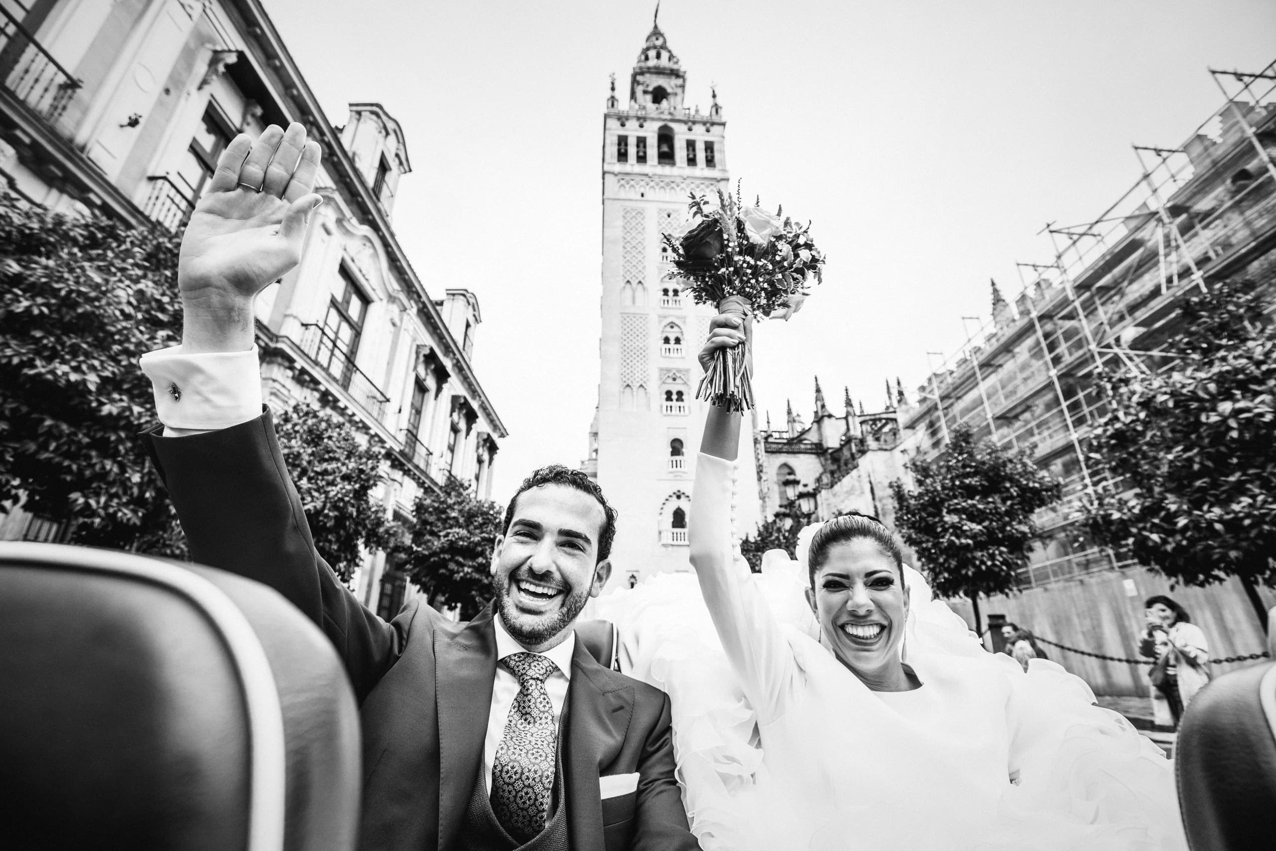 Los novios saludando desde el descapotable con la Giralda al fondo