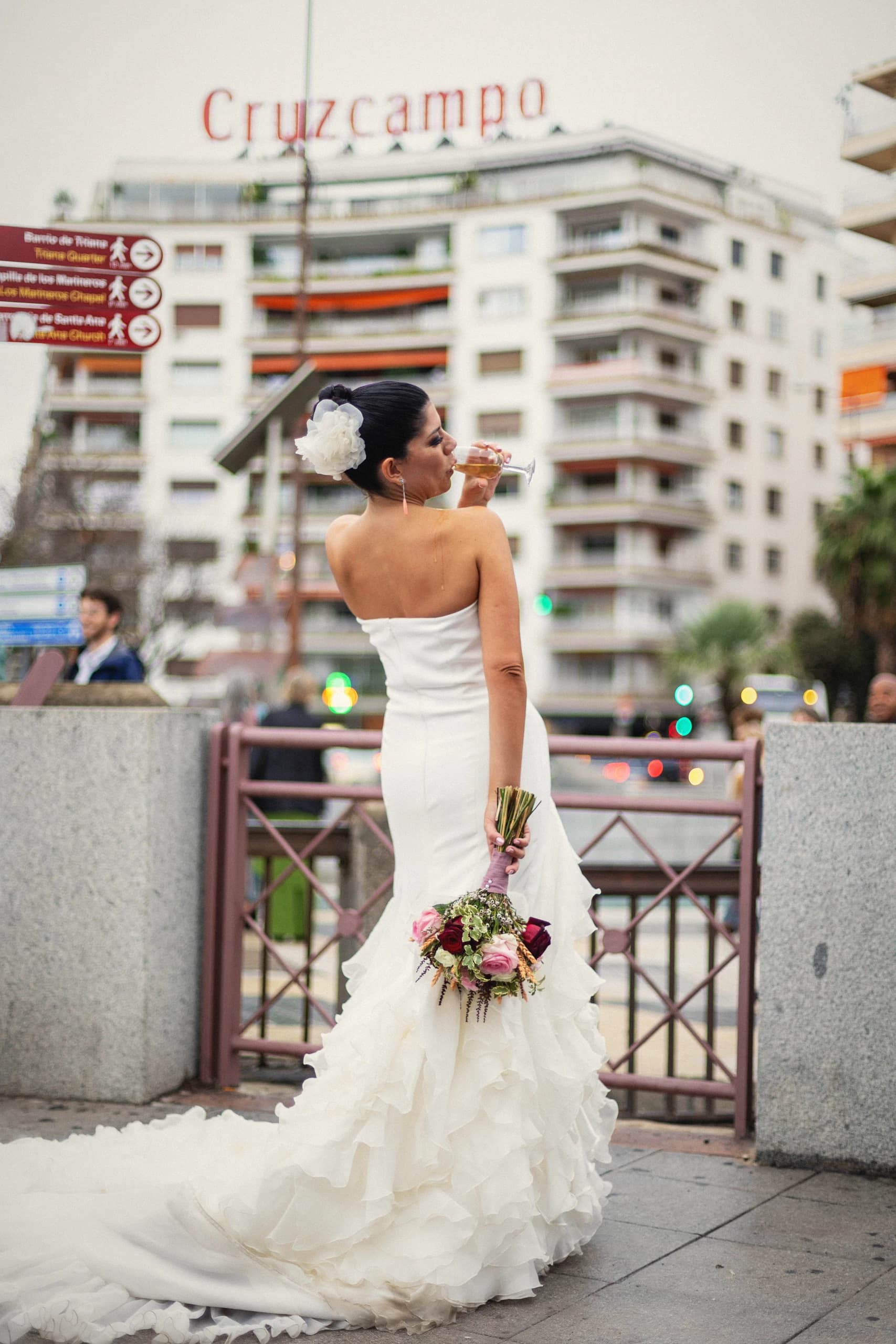 La novia con el ramo en el puente, con el vestido de cola