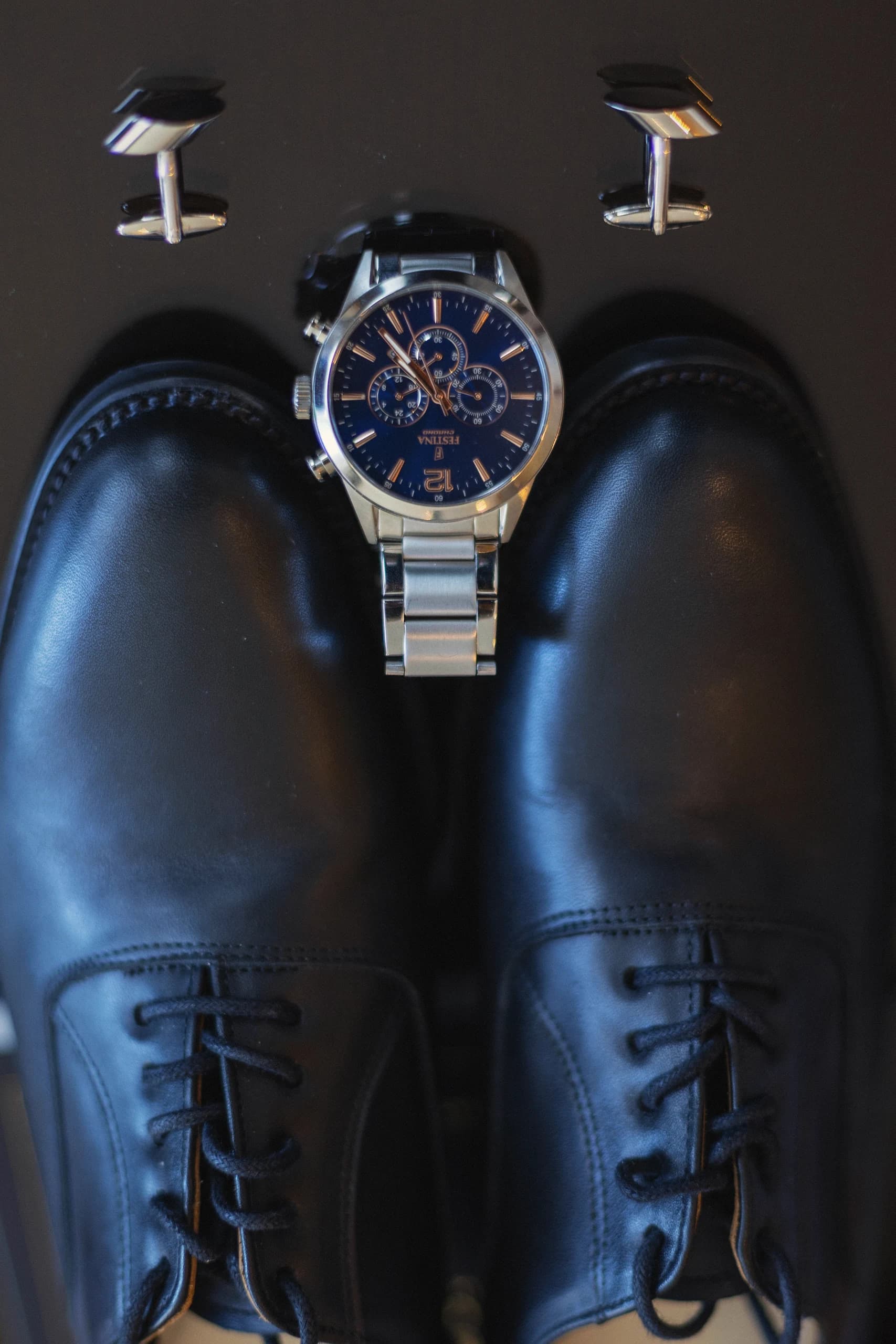 Los zapatos y el reloj del novio, listos sobre la cómoda