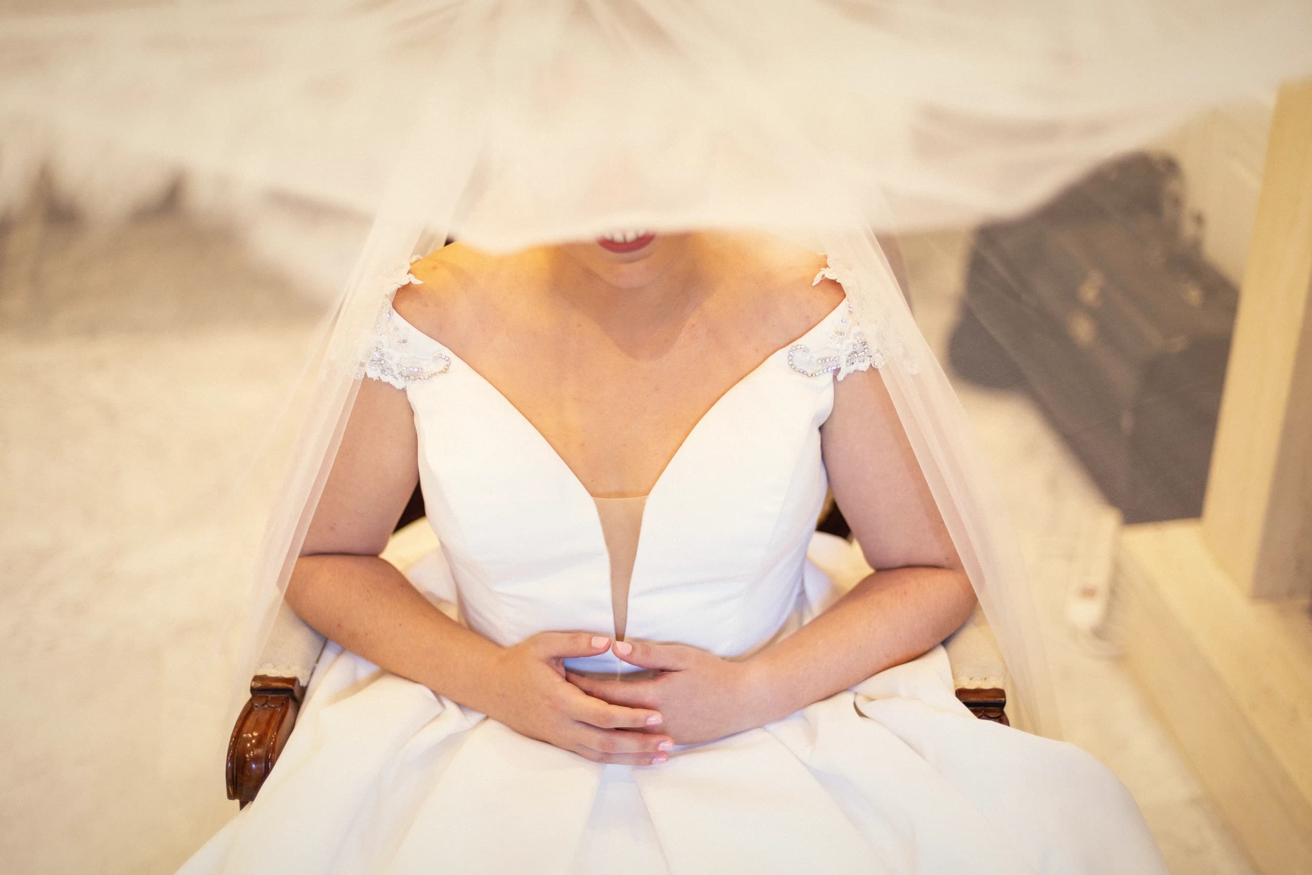 La novia sentada, con el velo cayéndole por delante