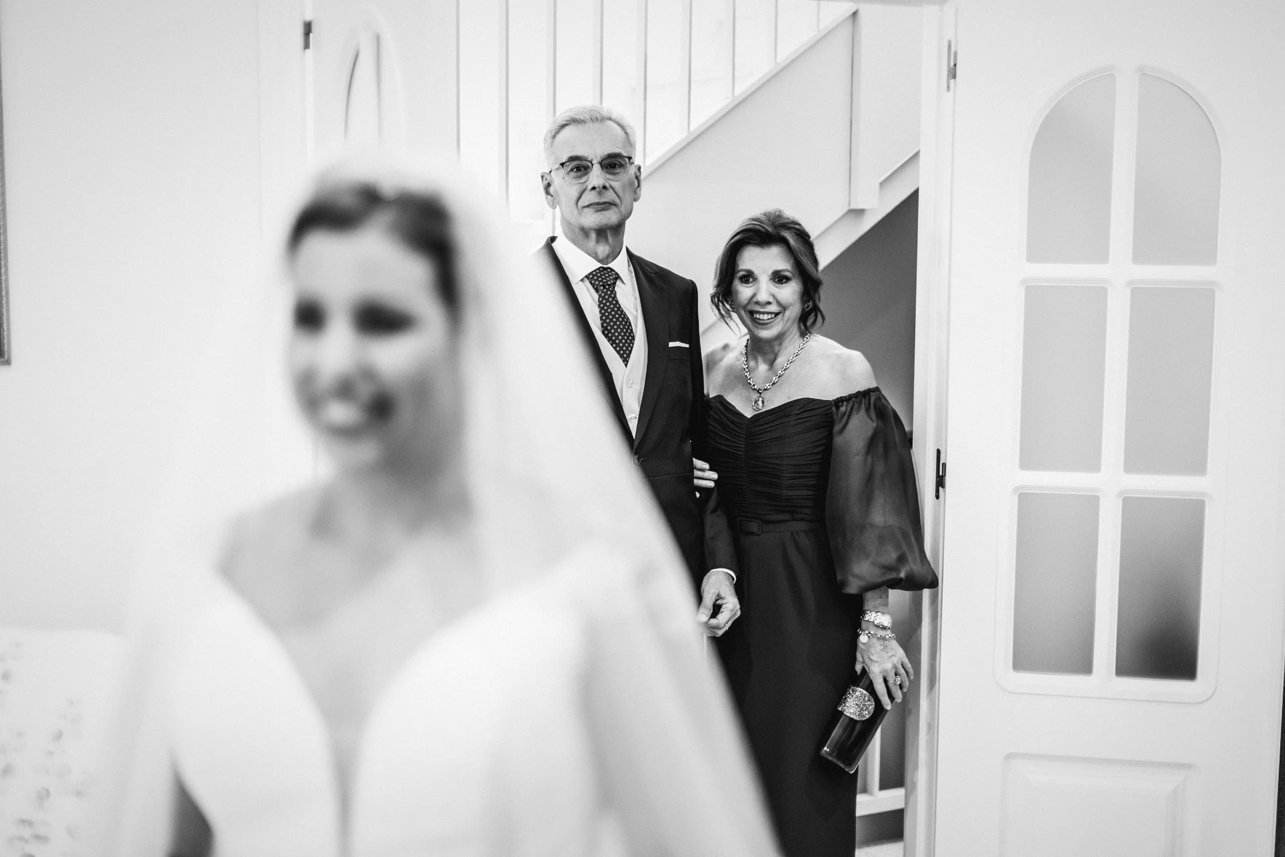 La novia bajando la escalera con sus padres, en blanco y negro