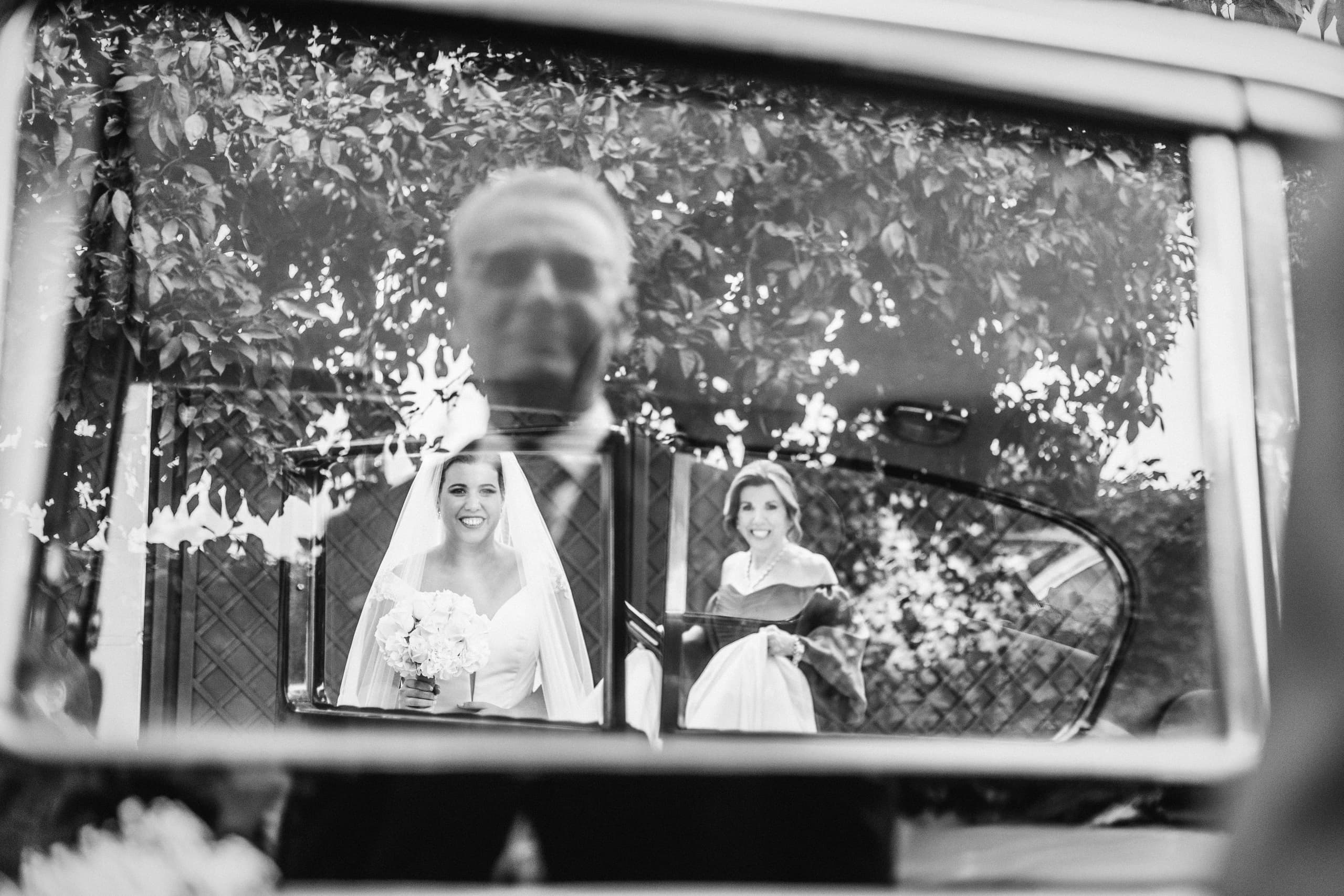 La novia reflejada en la ventanilla del coche clásico, en blanco y negro