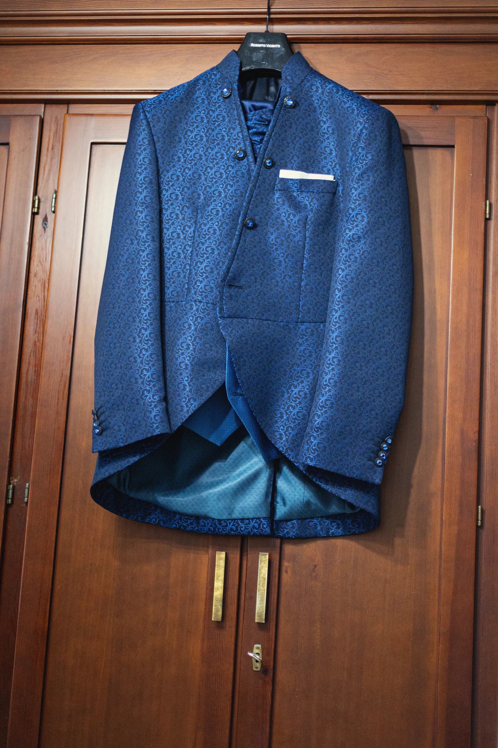 La chaqueta azul de brocado colgada del armario