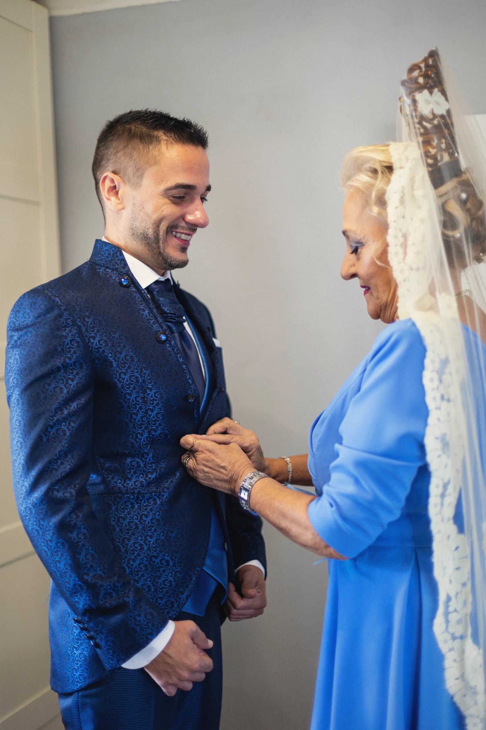 Uno de los novios con su madre, vestida de azul, antes de salir
