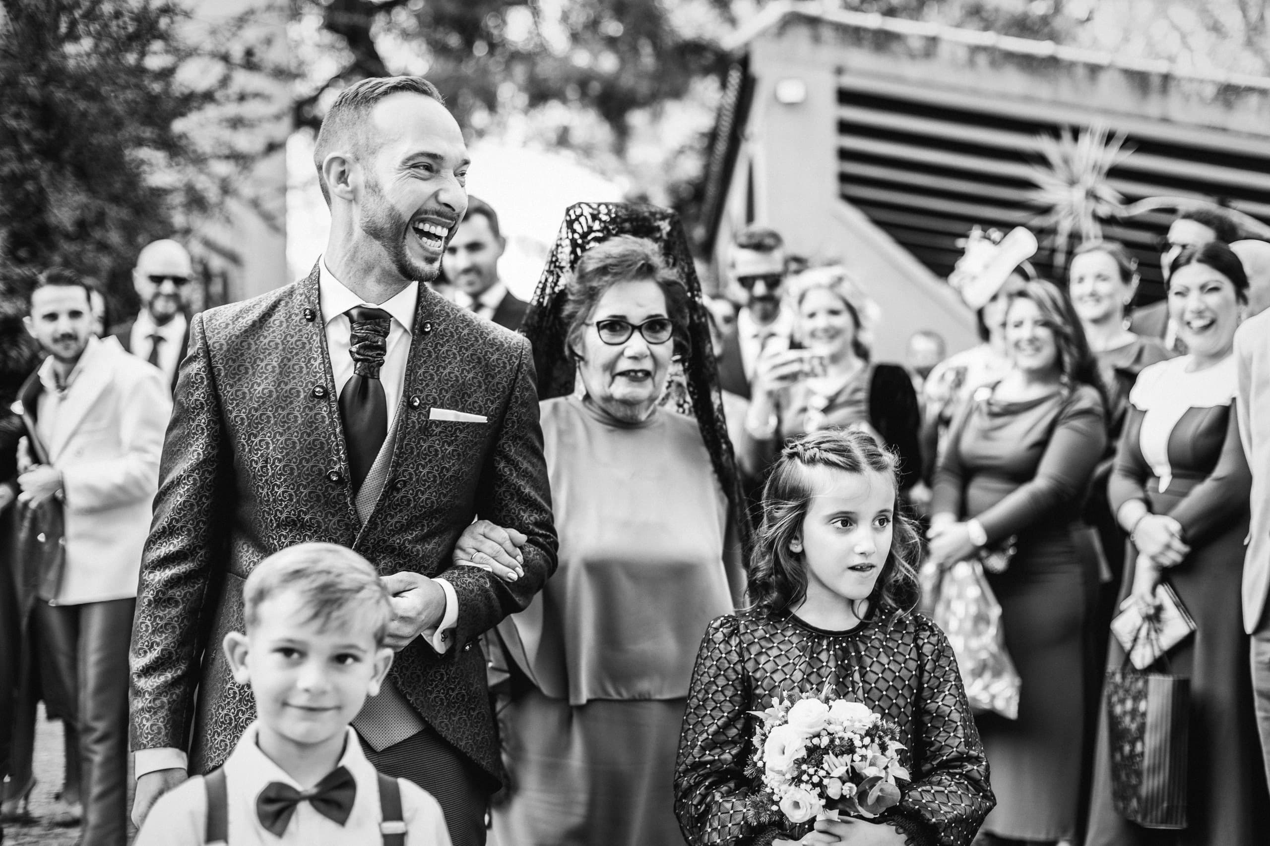 La entrada de uno de los novios del brazo de su madre, en blanco y negro