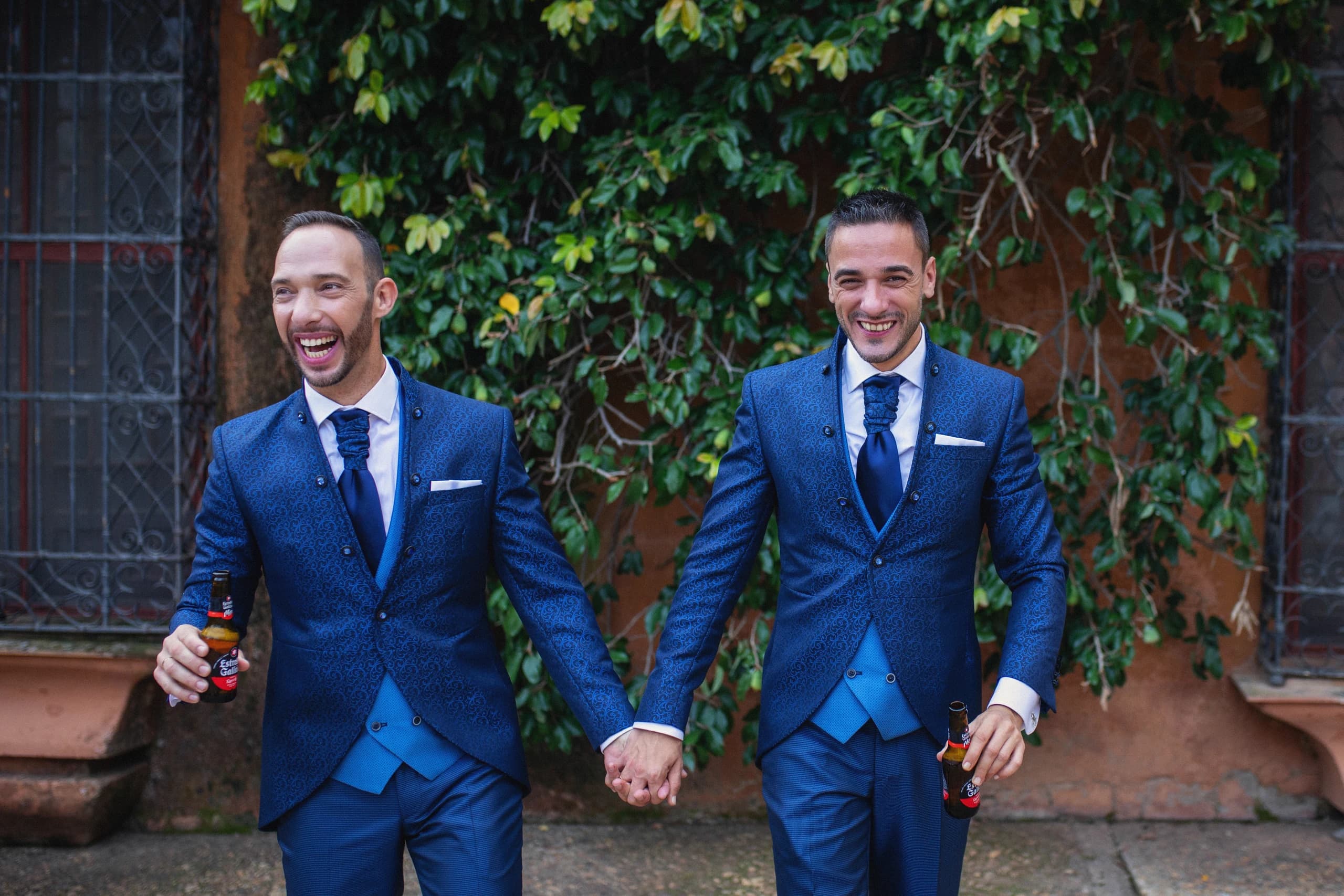 Los novios caminando de la mano y riendo por el patio