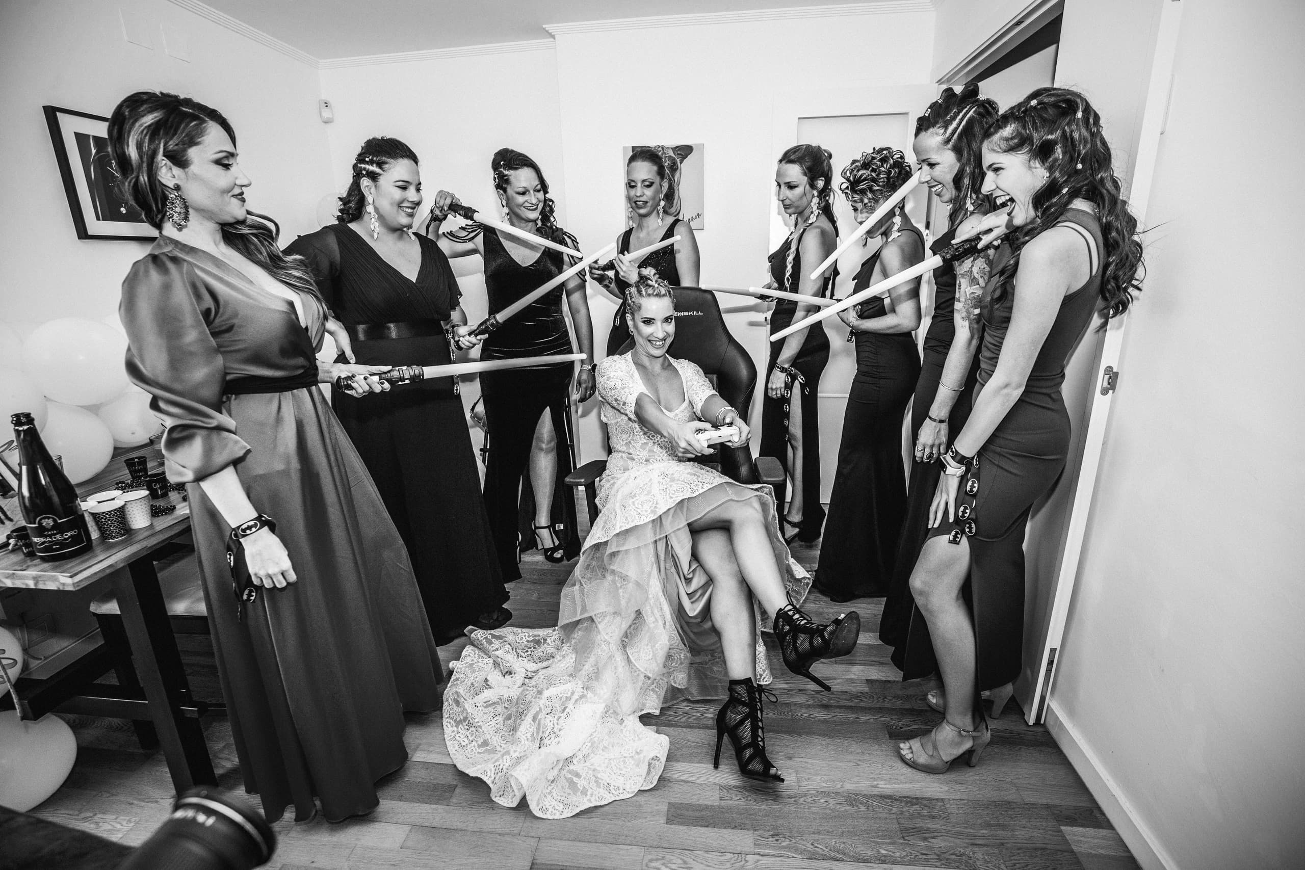 Las amigas con sables de luz alrededor de la novia, en blanco y negro