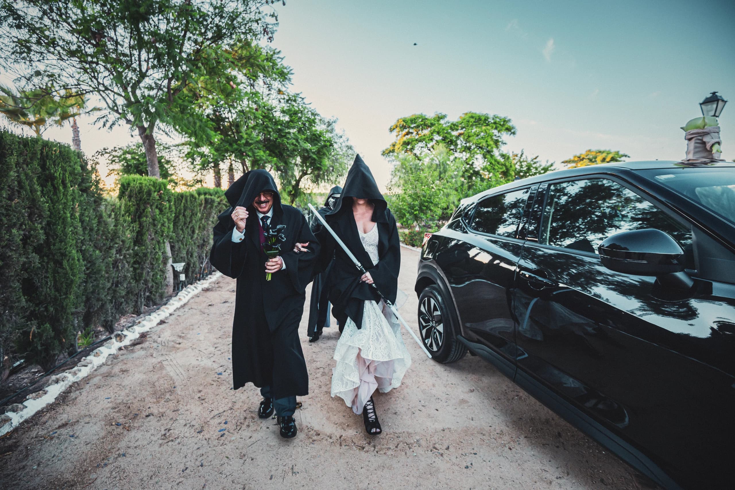 Los invitados con capas negras llegando junto al coche