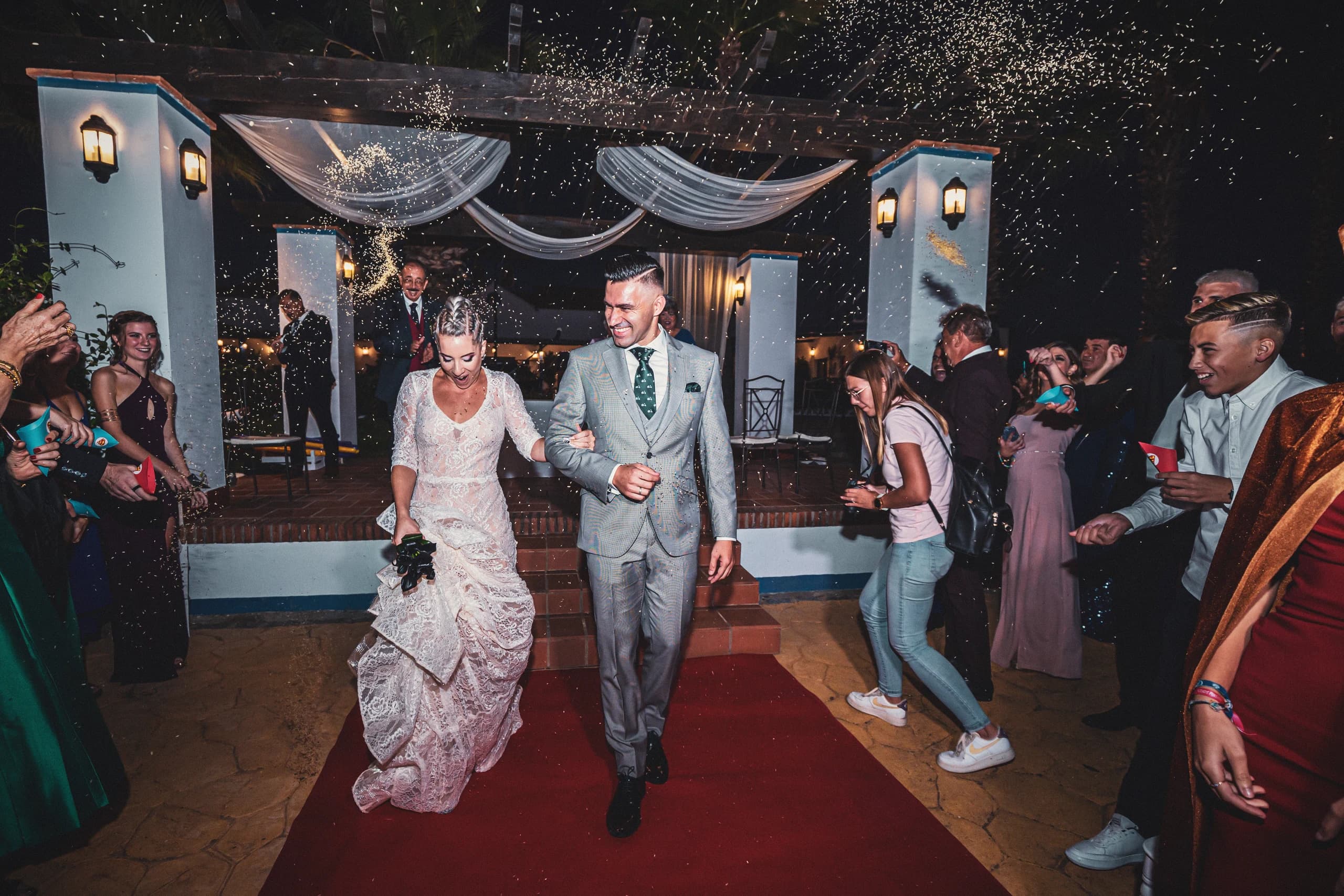 Los novios saliendo por la alfombra roja entre aplausos