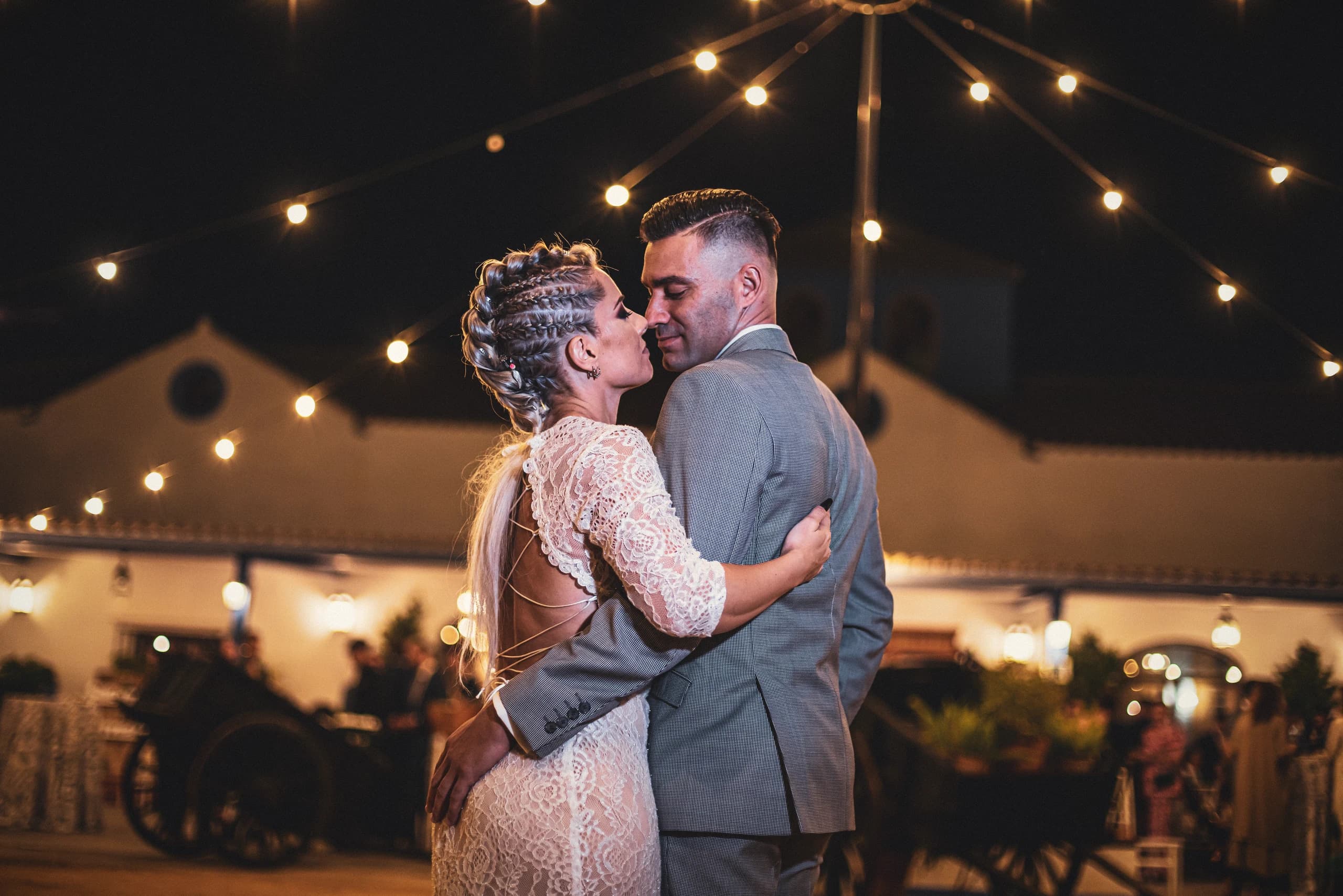 Los novios bailando bajo las luces de la fiesta