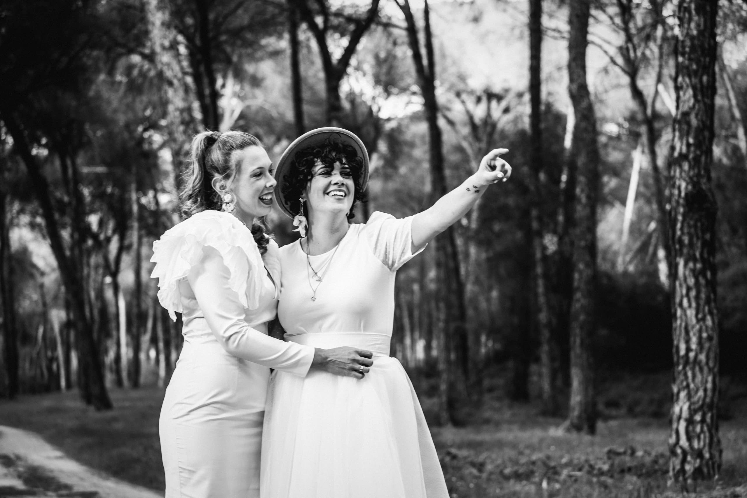 Las dos señalando algo fuera de cuadro, muertas de risa, en blanco y negro