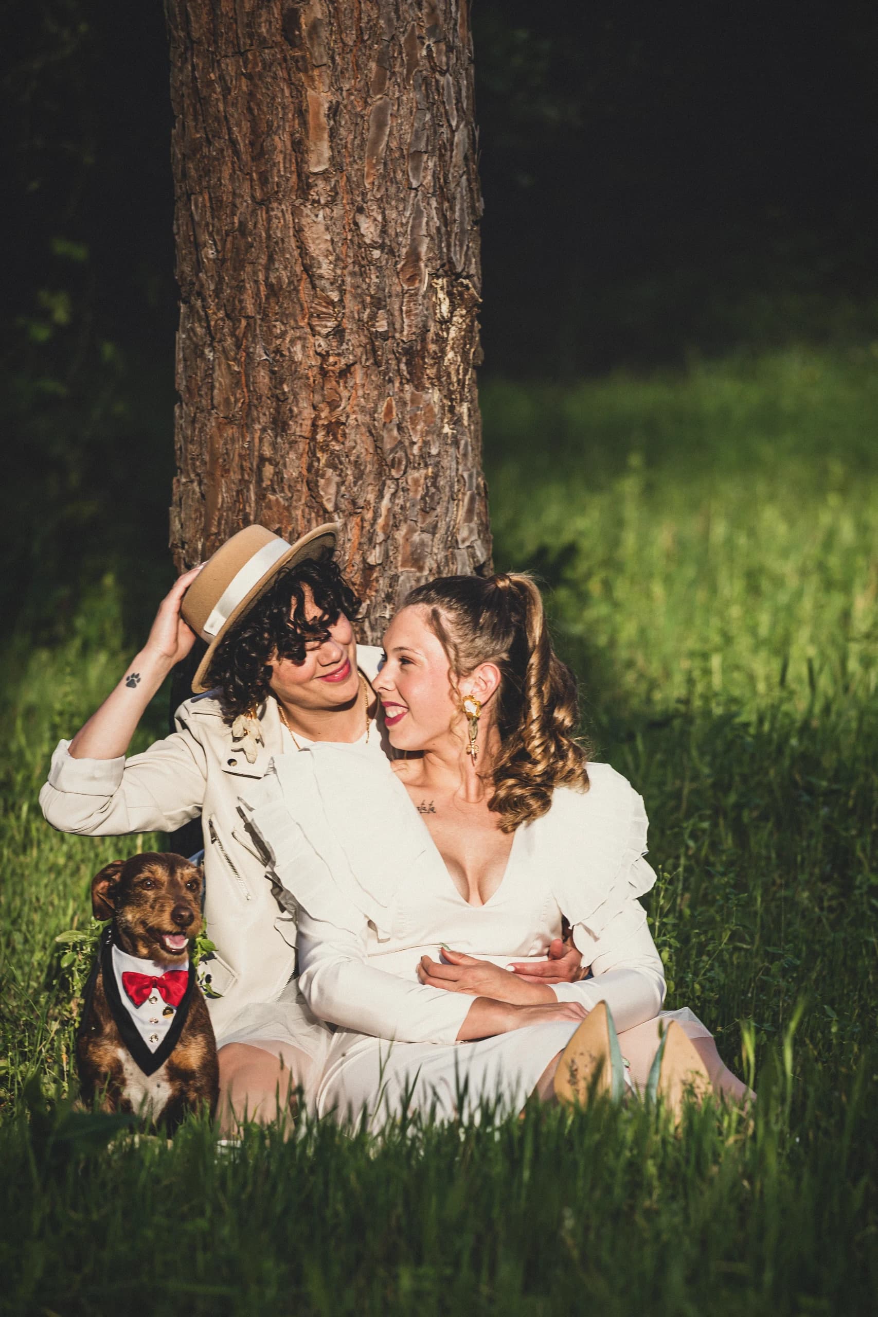 Retrato cercano de las dos con el sombrero y el perro asomando abajo