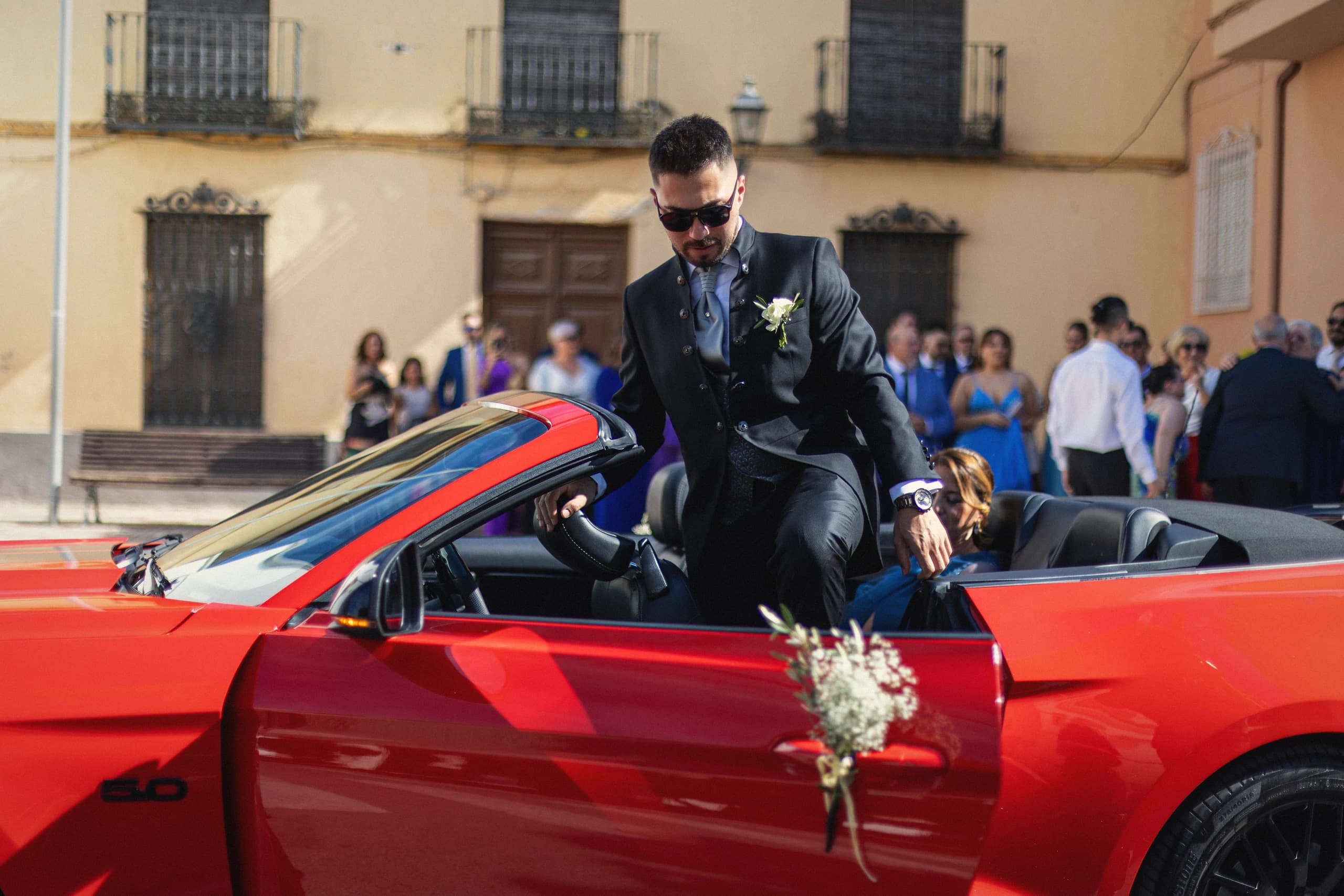El novio llegando en el Mustang rojo descapotable
