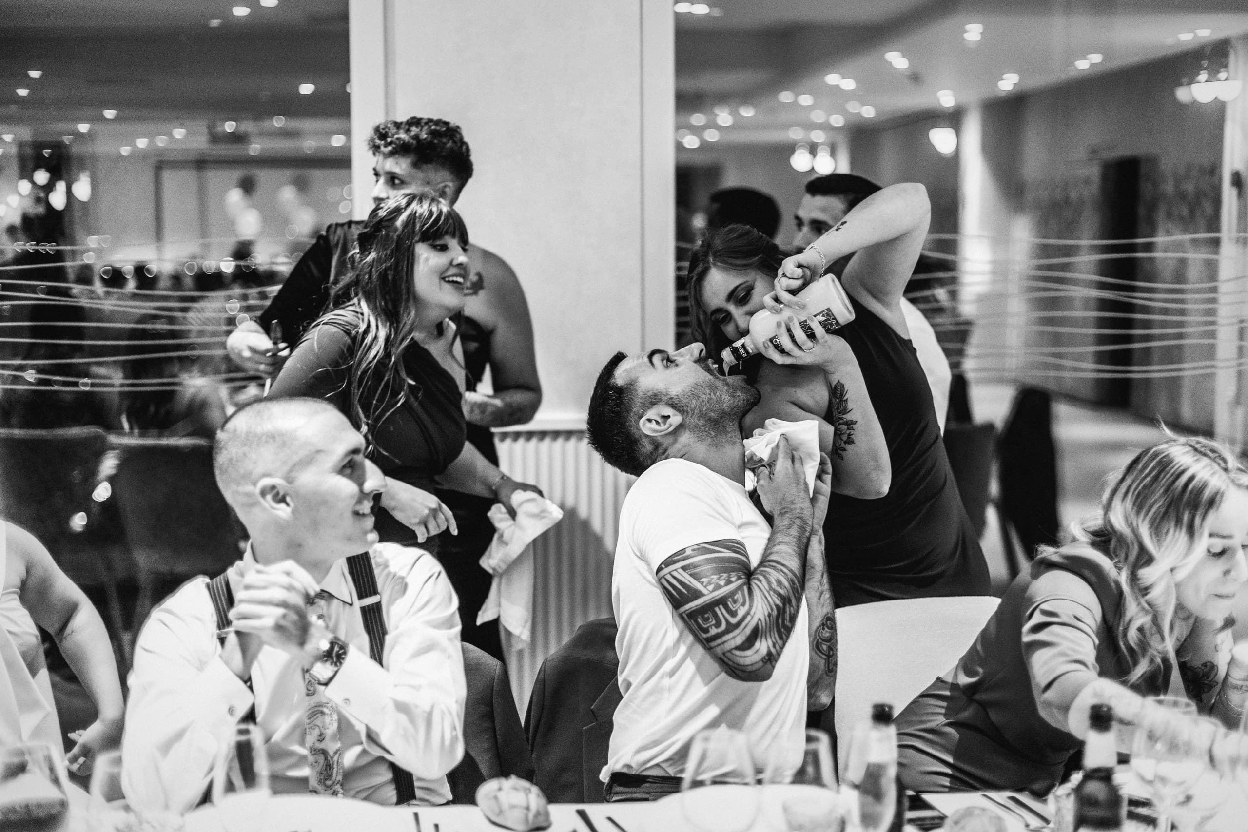 Los invitados riendo en la mesa, en blanco y negro