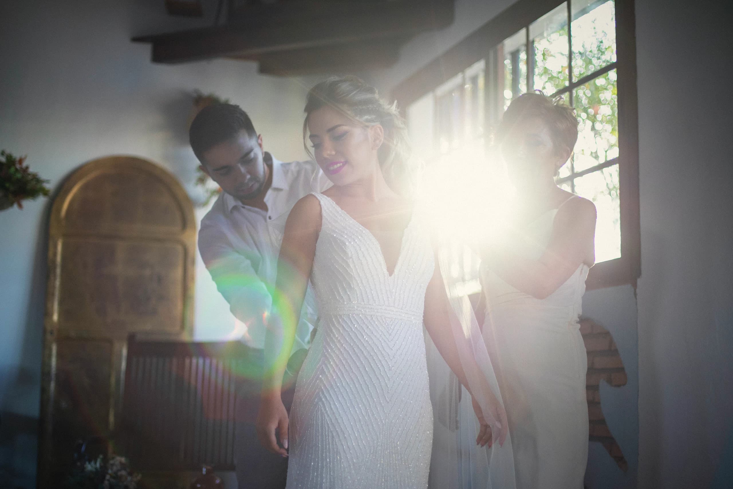 La novia y su madre a contraluz durante los preparativos