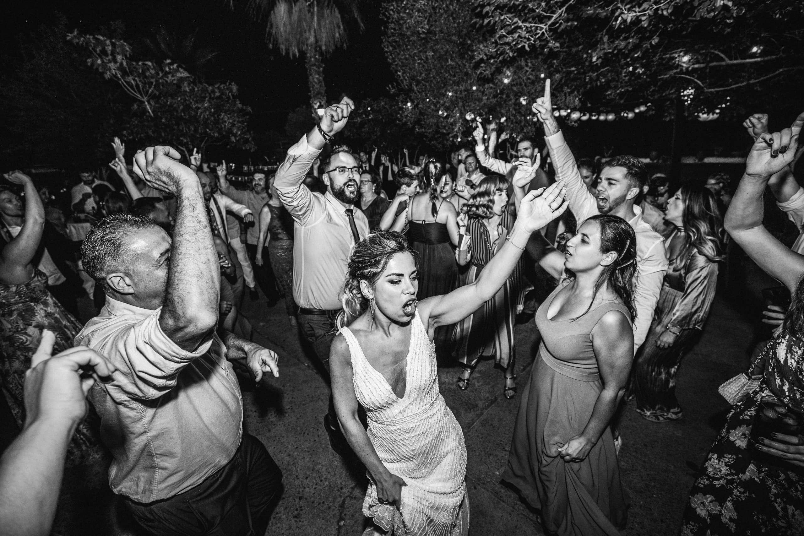 Los invitados bailando bajo las luces, en blanco y negro