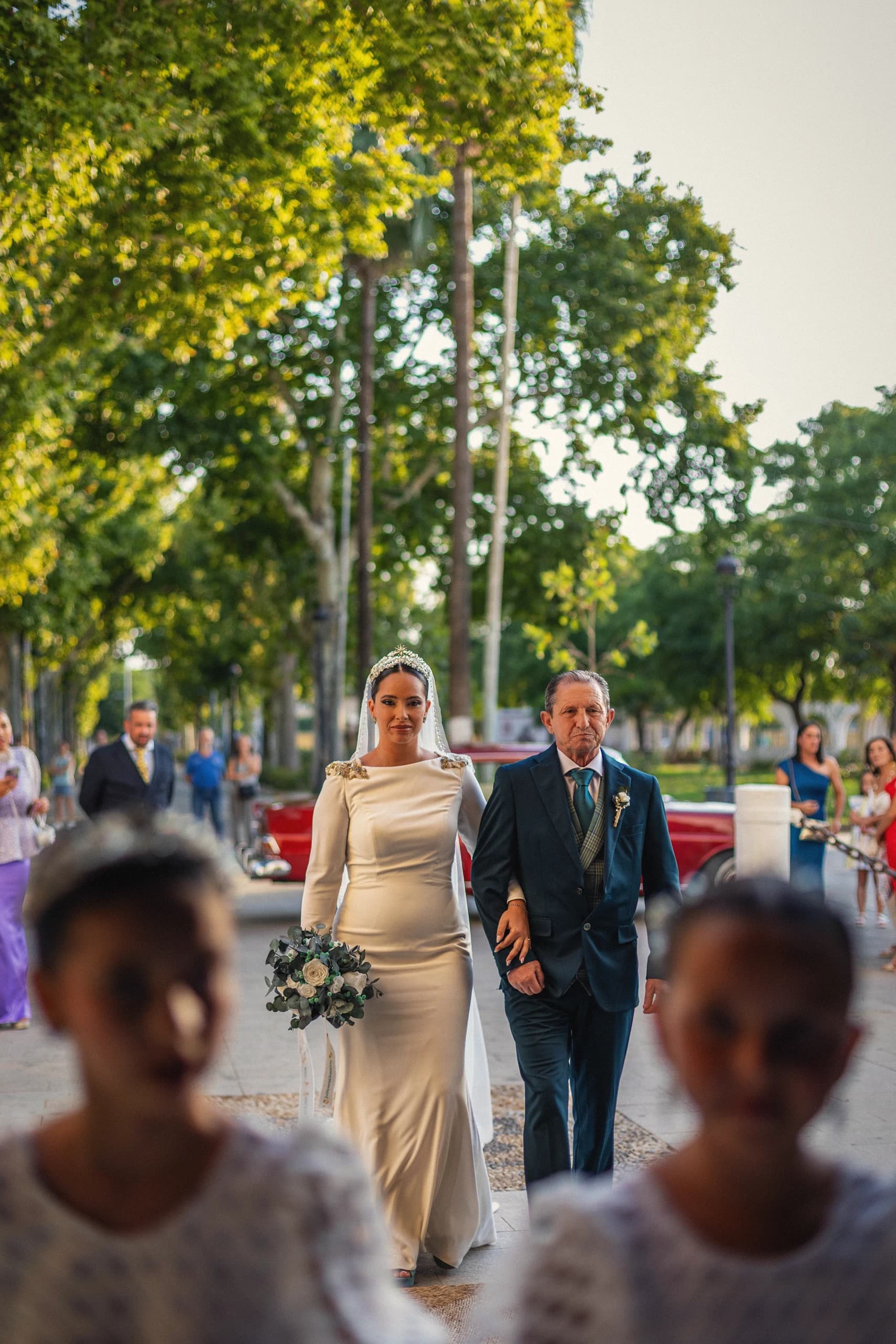 La novia entrando del brazo de sus padres, con los niños delante