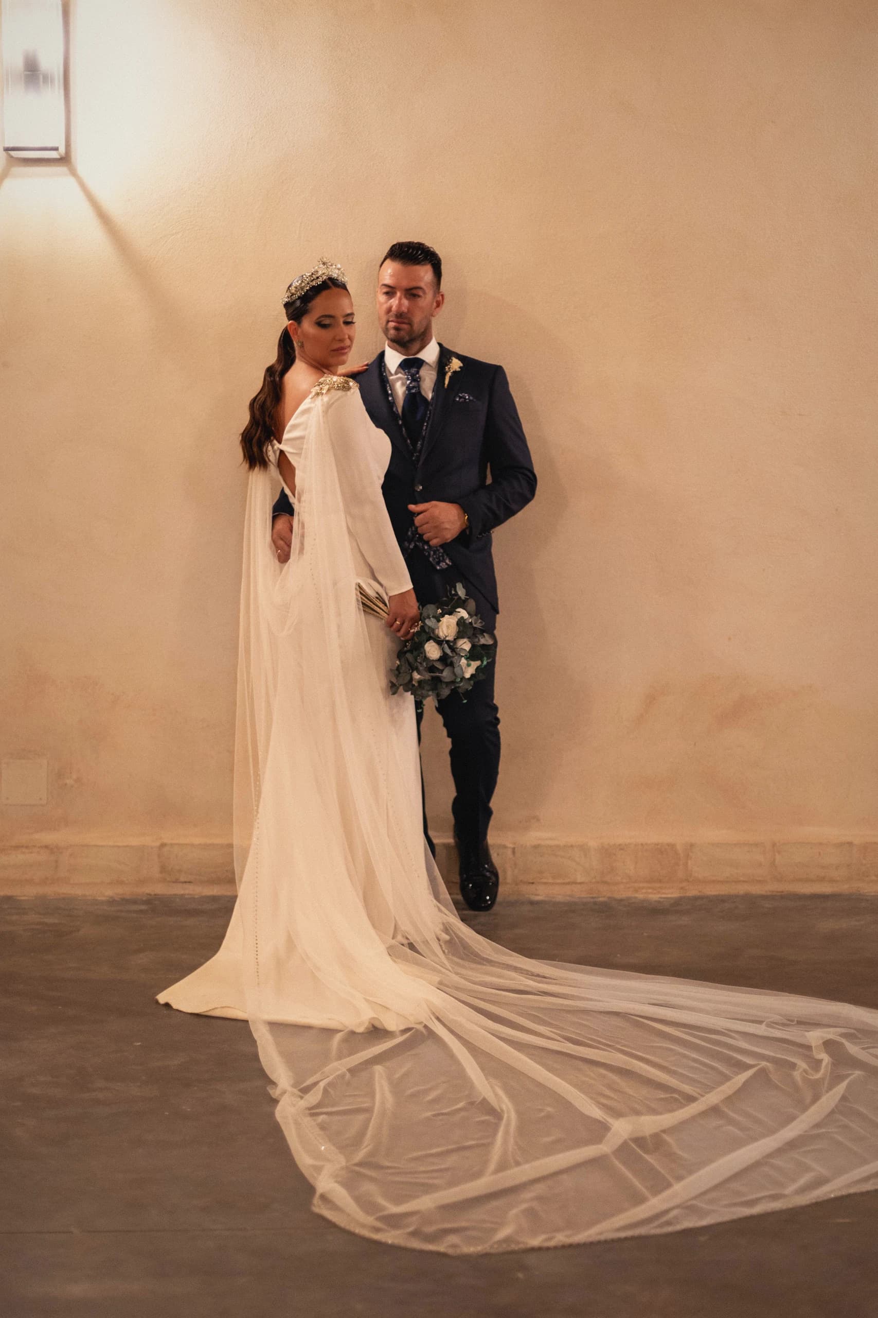 Los novios con la cola del vestido extendida sobre el suelo