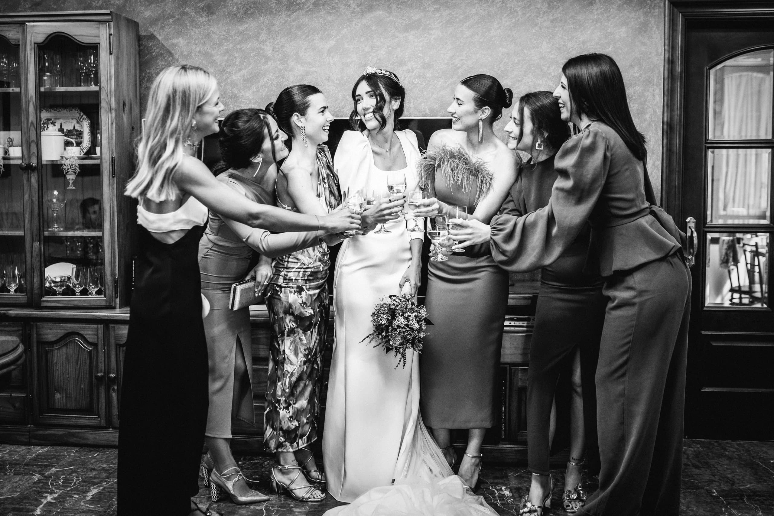 Las amigas de la novia colocándole el velo, en blanco y negro