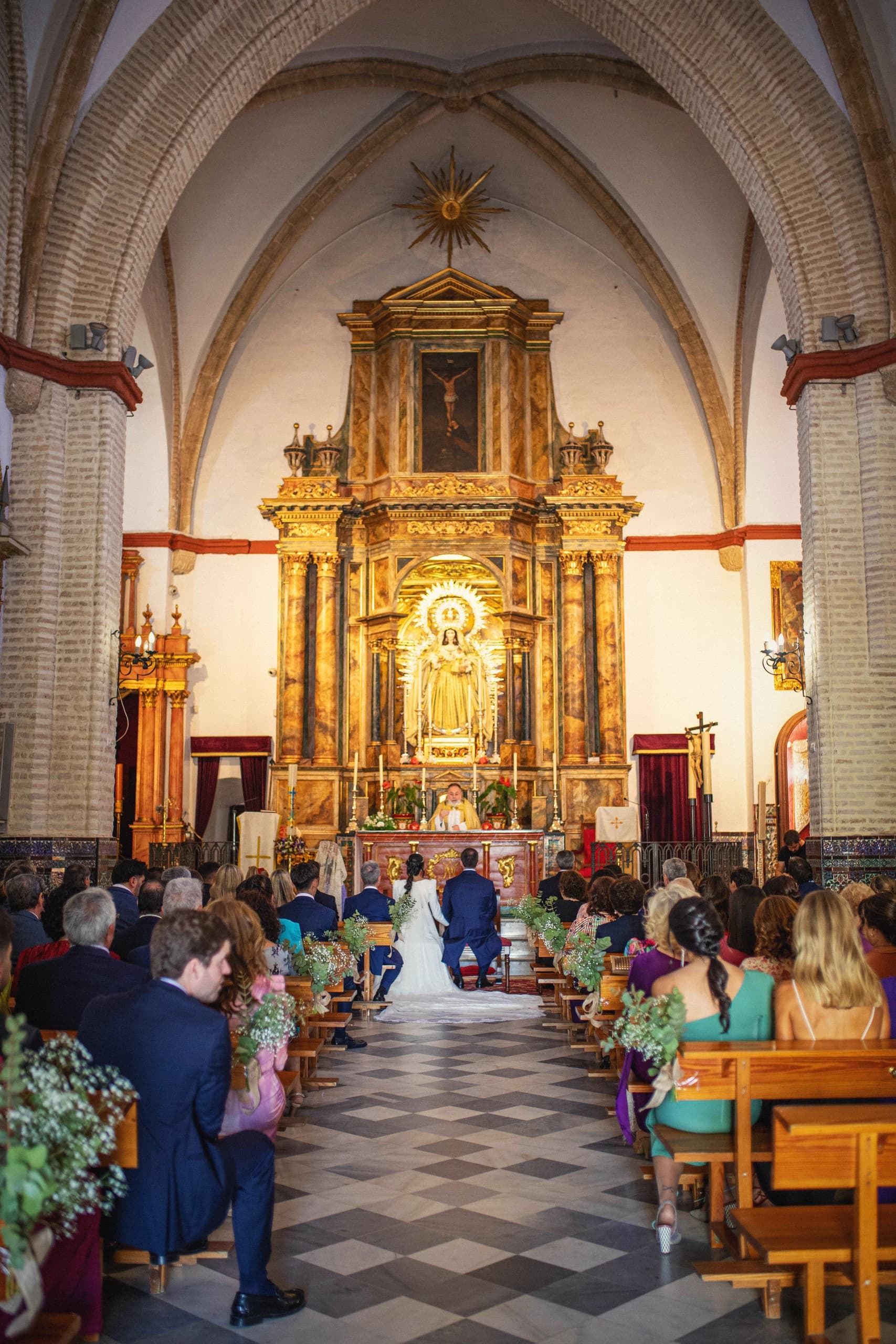 La ceremonia vista desde el fondo de la iglesia con el retablo dorado