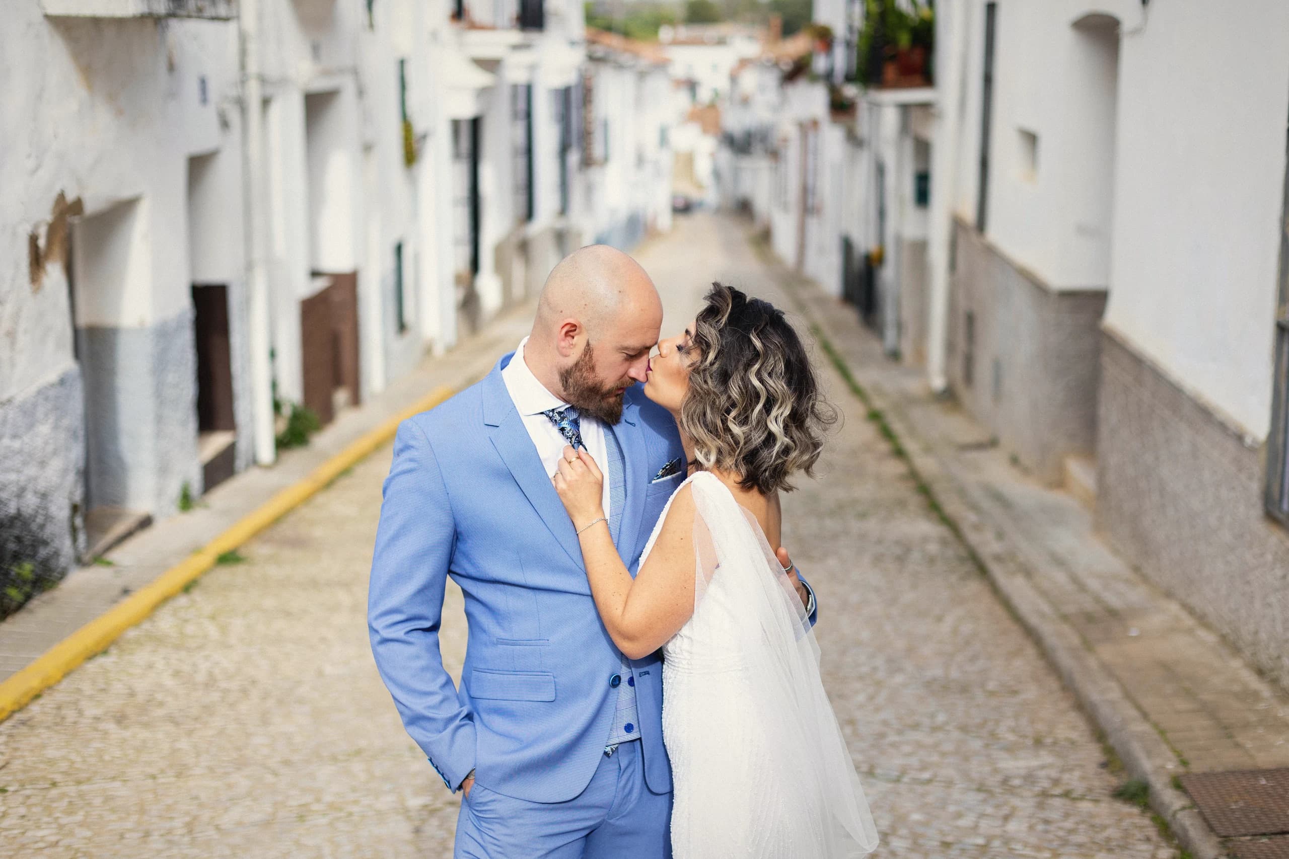 Beso en mitad de la calle del pueblo blanco