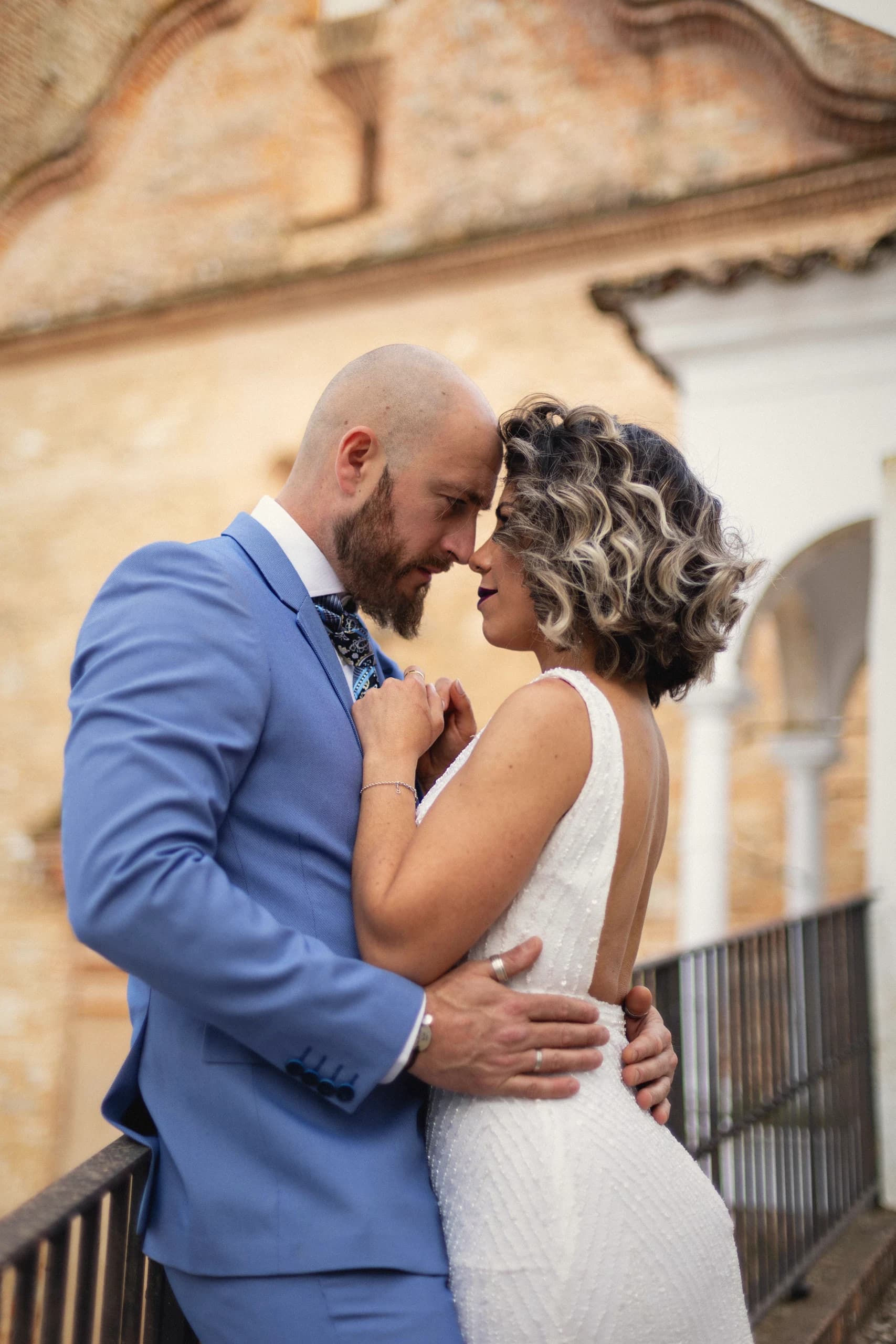 Abrazo frente a la fachada de ladrillo de la ermita