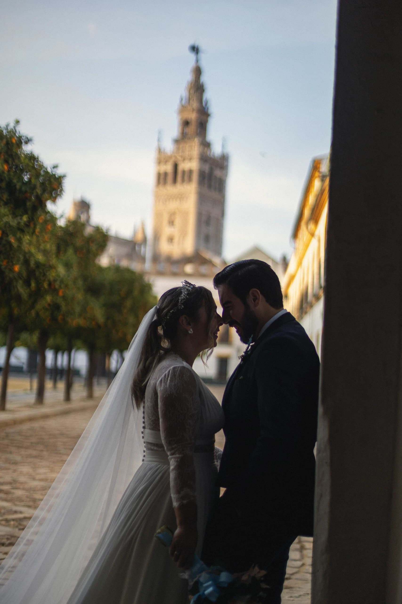 Silueta de los novios a contraluz con la Giralda entre los naranjos