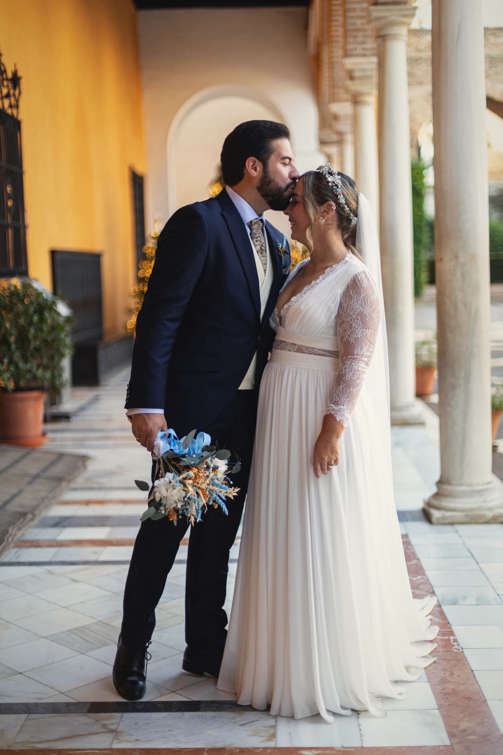 Beso en el porche de columnas junto al árbol de Navidad