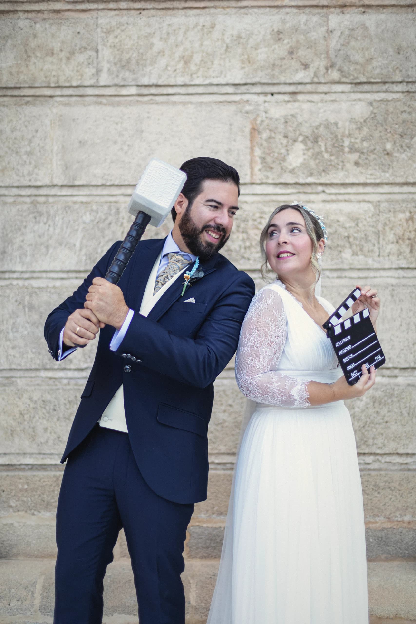 Los novios jugando con una claqueta y un martillo de utilería, riéndose