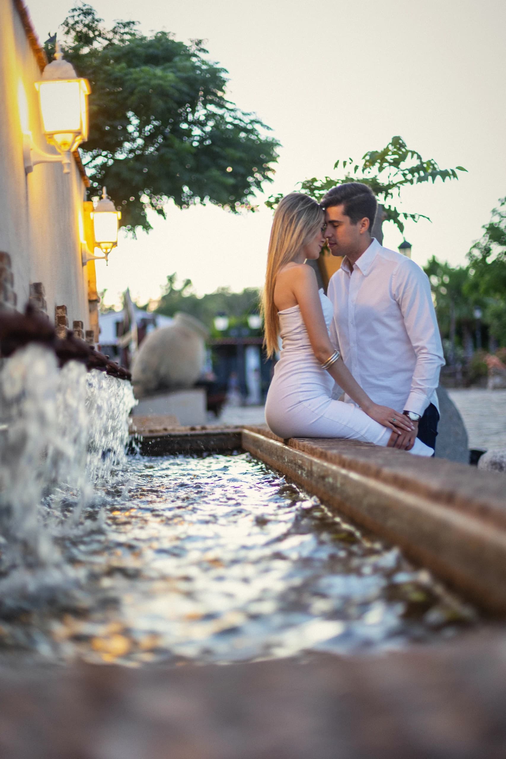 Sentados en el borde de la fuente, con el agua cayendo en primer plano